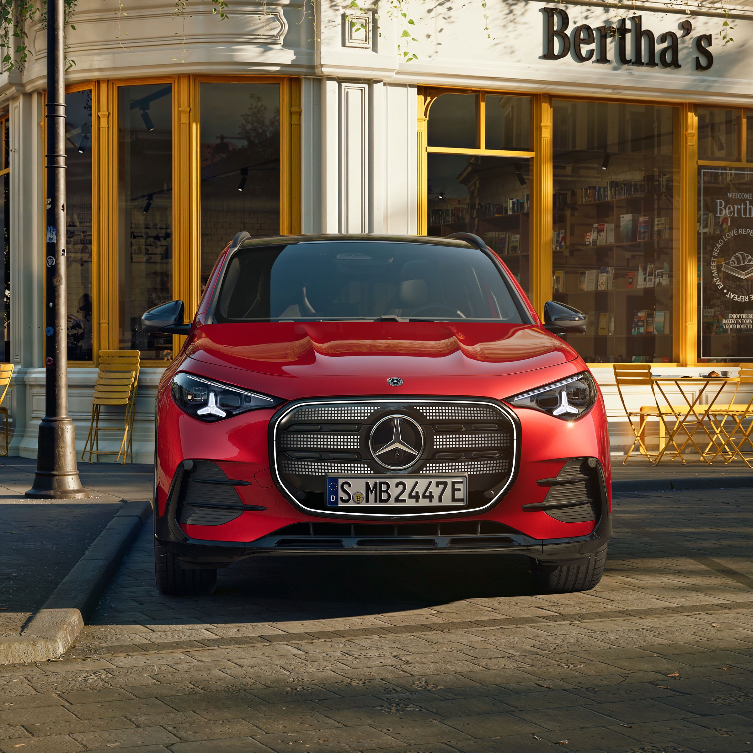 Der neue elektrische GLA stehend vor einem Cafe.