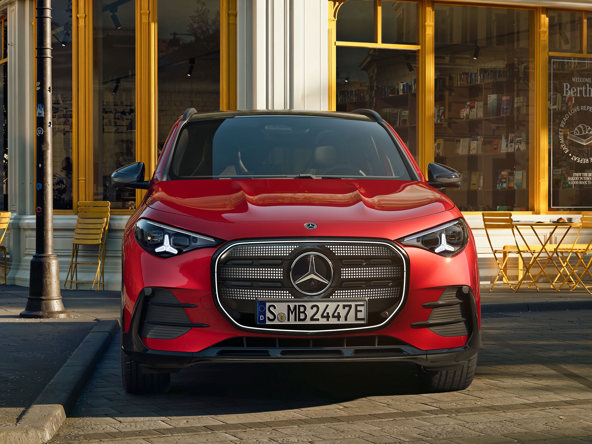 Ein roter elektrischer GLA stehend vort einem Café.