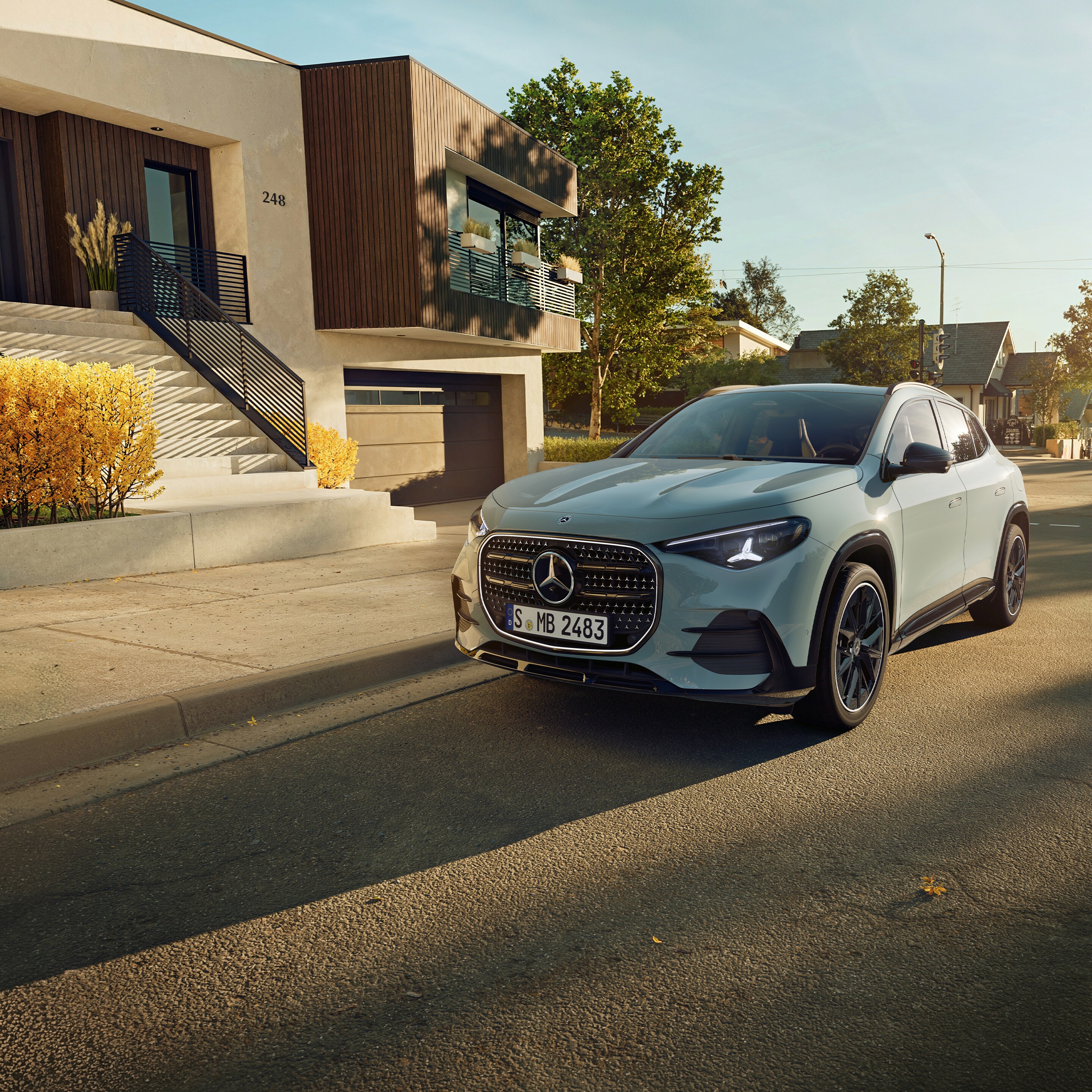 Der neue Mercedes-Benz GLA stehend auf einer Straße vor einem Wohnhaus.