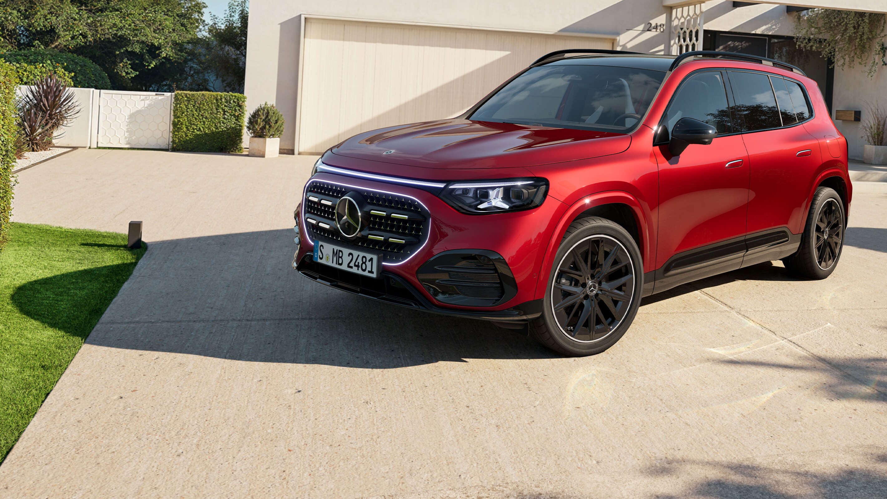 Ein roter GLB SUV steht auf einer Auffahrt zu einem Wohngebäude.