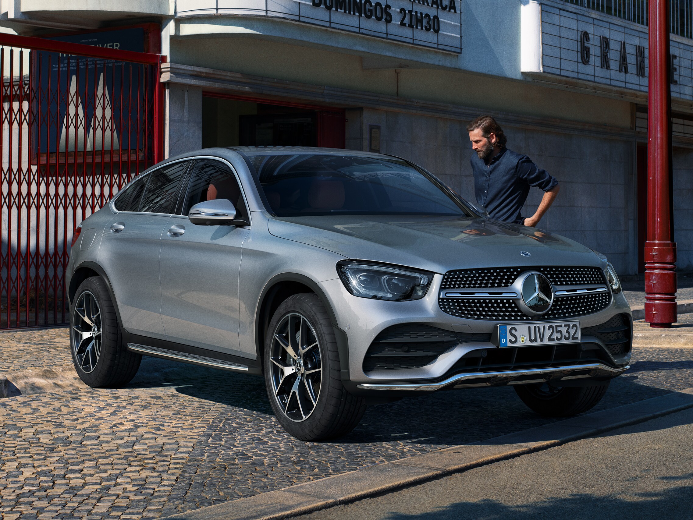 Ein Mann steht an einem silbernen GLC Coupé.