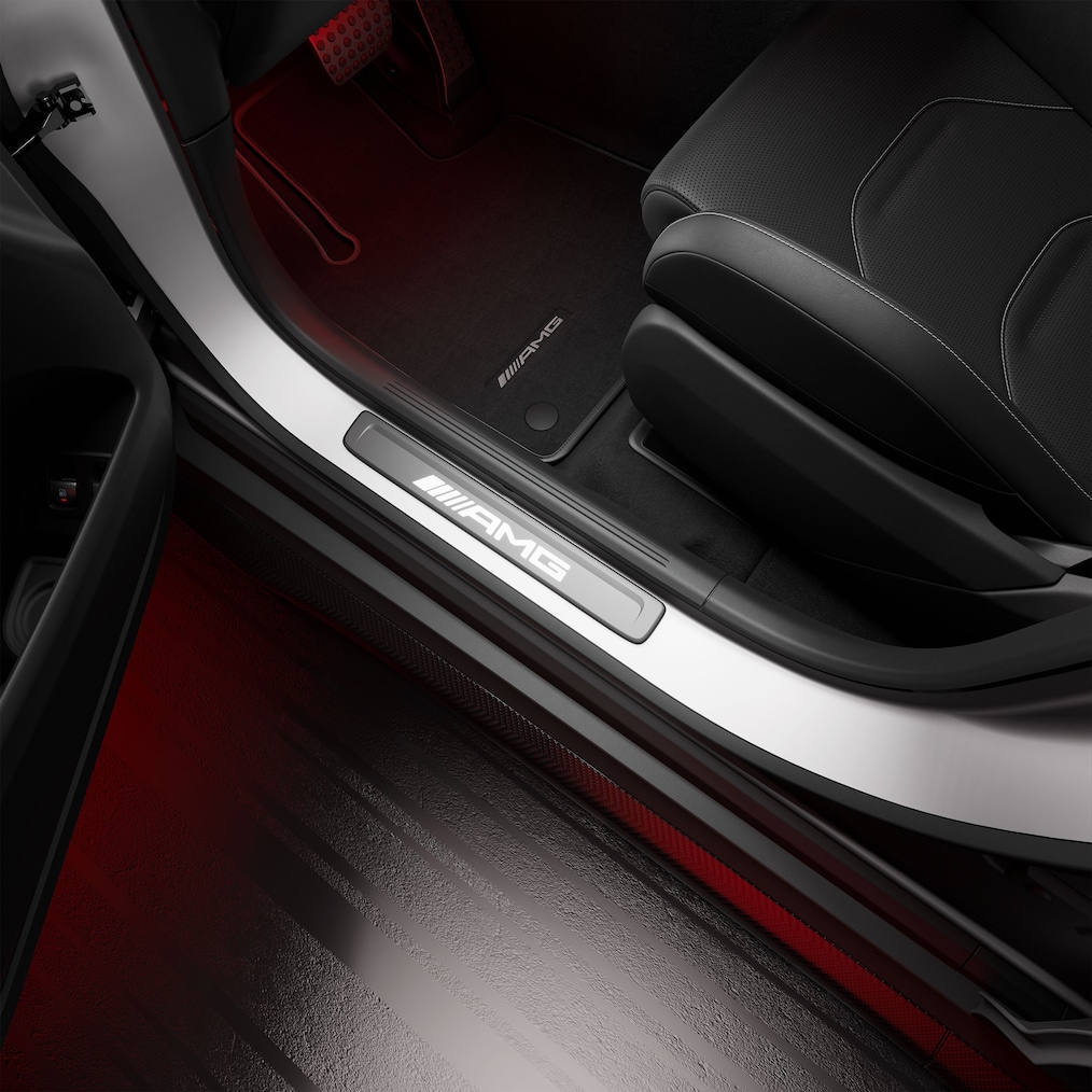 Detailaufnahme von AMG Einstiegsleisten, die mit "AMG" Schriftzug beleuchtet sind.