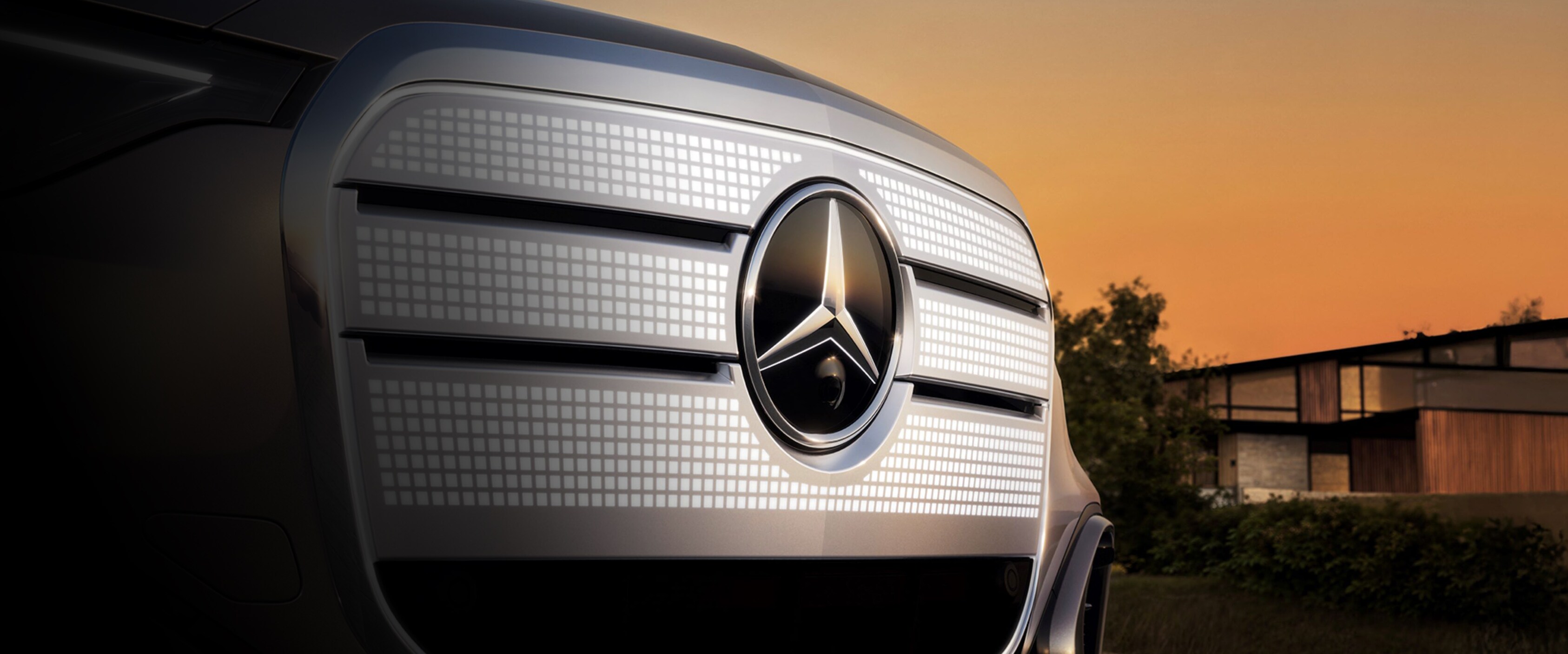 Der neue GLC BEV beklebt mit Folie, fährt in einer Schneelandschaft mit Bäumen und blauen Himmel.