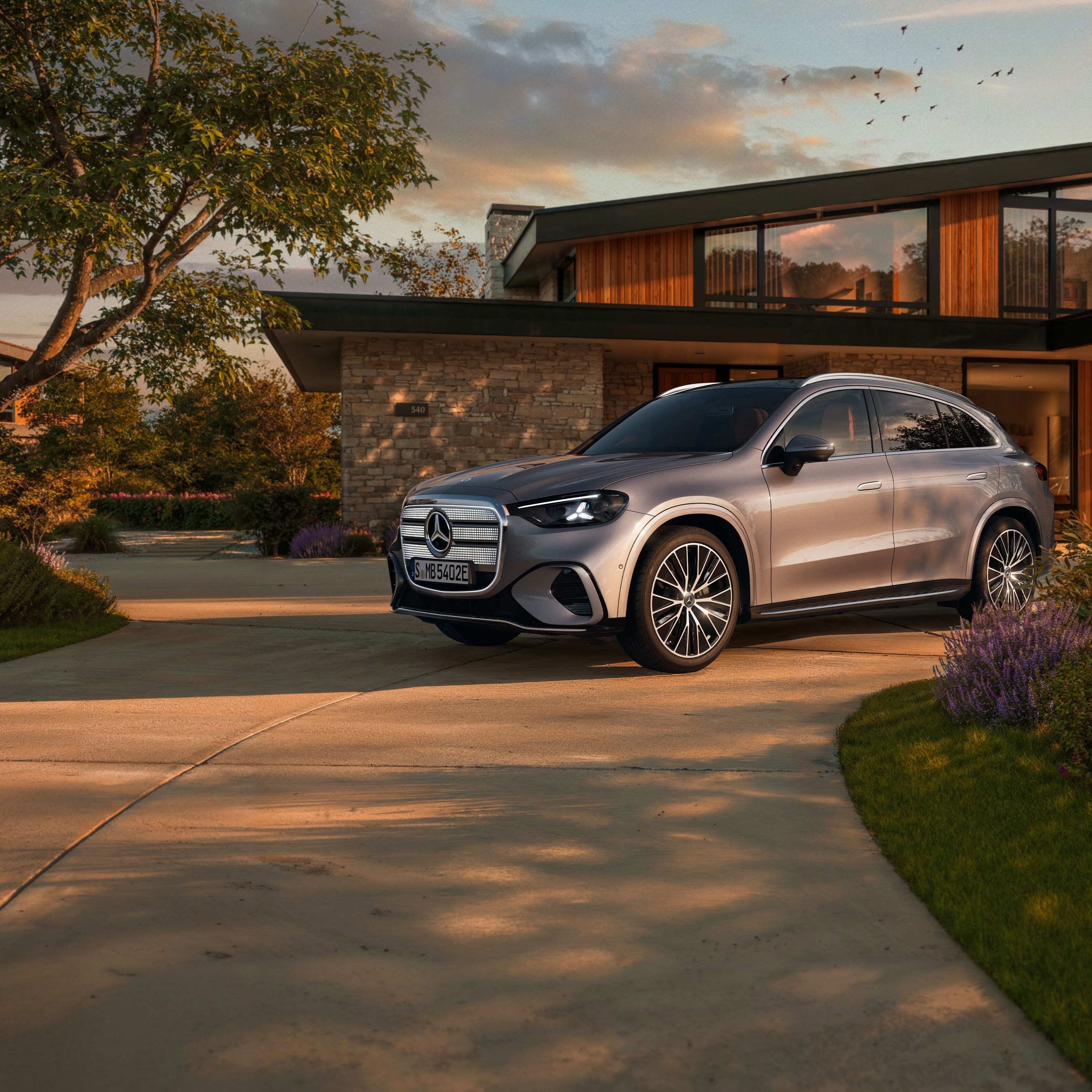 Der elektrische Mercedes-Benz GLC SUV vor einer EInfahrt.