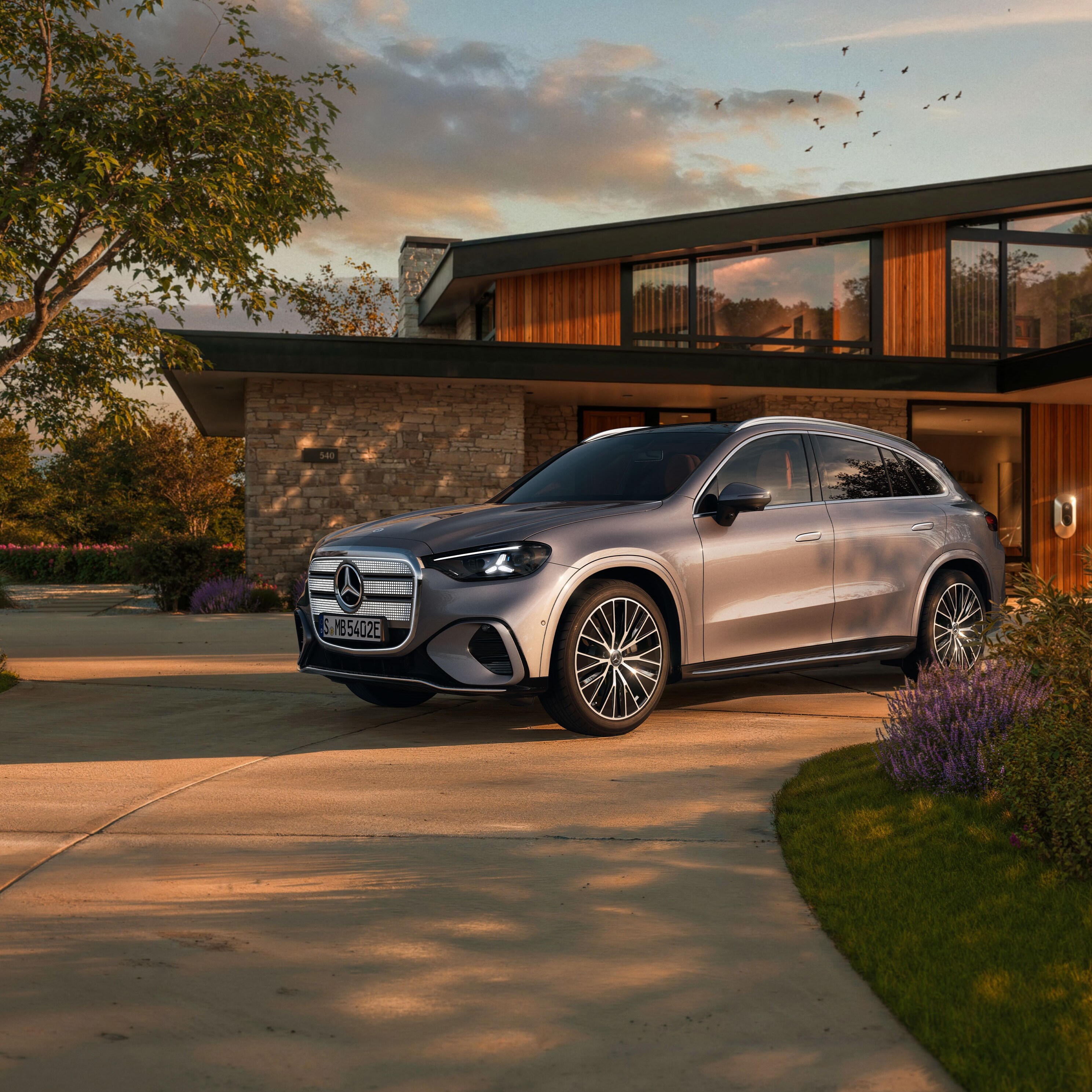 Der elektrische Mercedes-Benz GLC SUV vor einer EInfahrt.