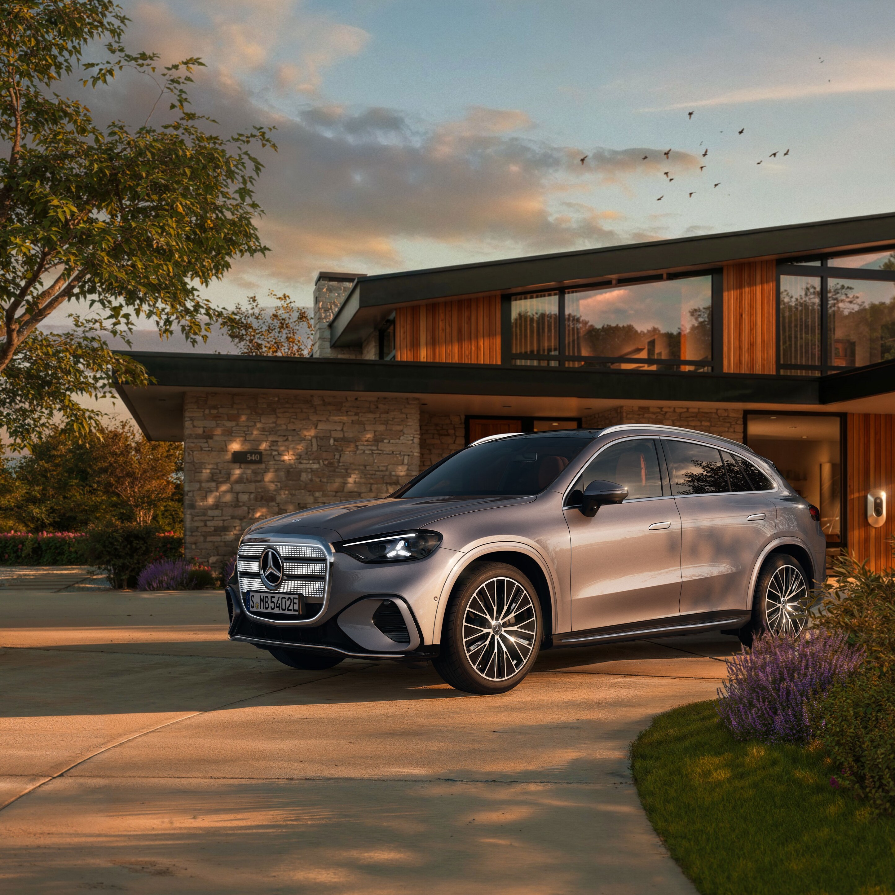 Der elektrische Mercedes-Benz GLC SUV vor einer EInfahrt.