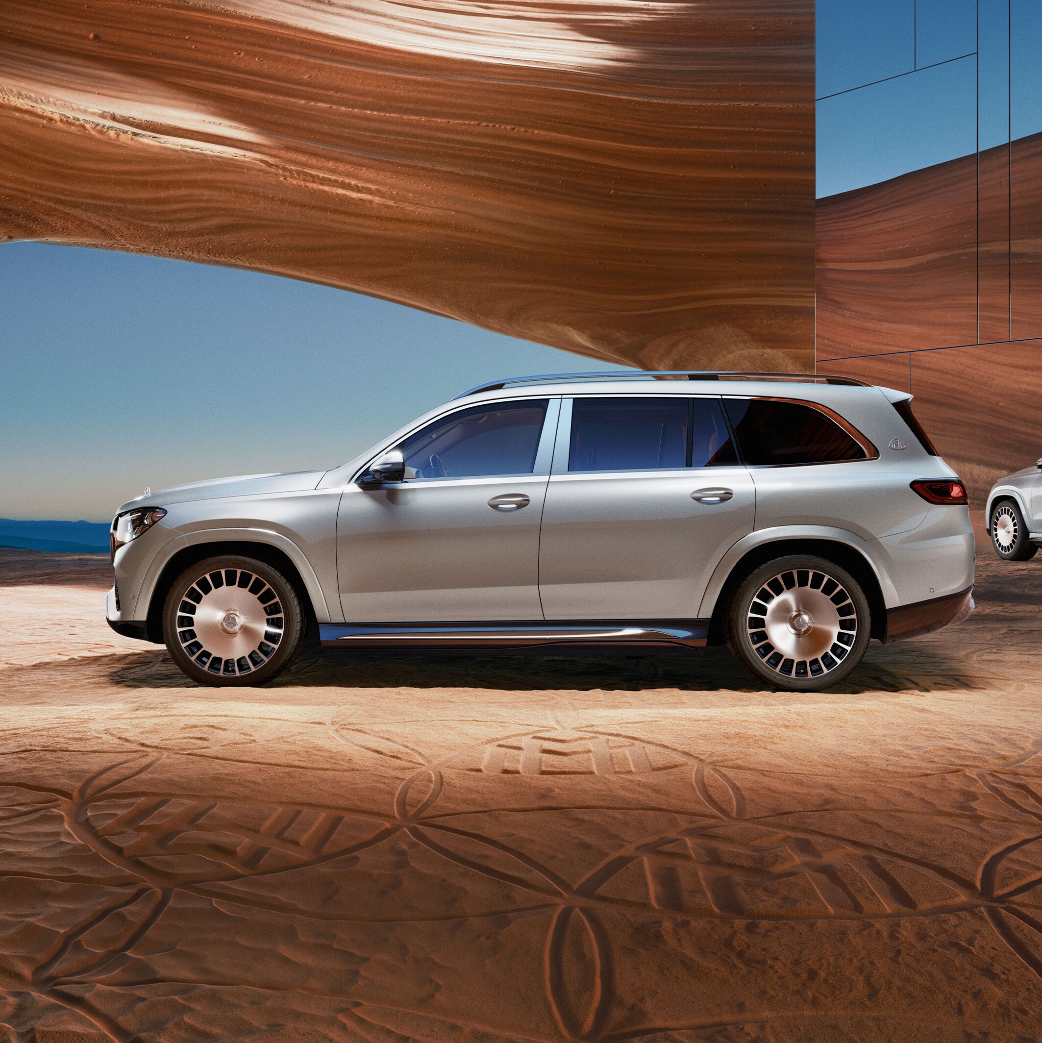 Ein silberner GLS von Mercedes-Maybach steht unter einem rötlichen Canyonbogen.