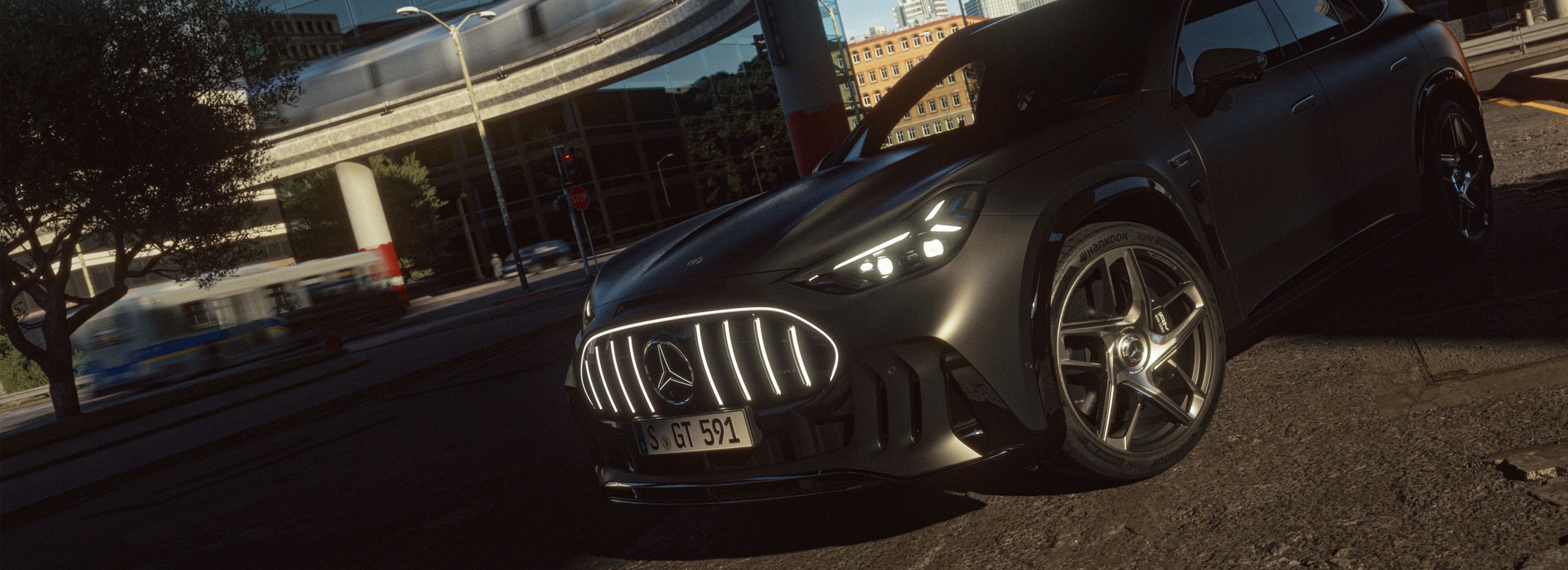 Ein schwarzer Mercedes.AMG GT SUV parkt mit angeschalteten Scheinwerfern unterhalb einer Schienentrasse.