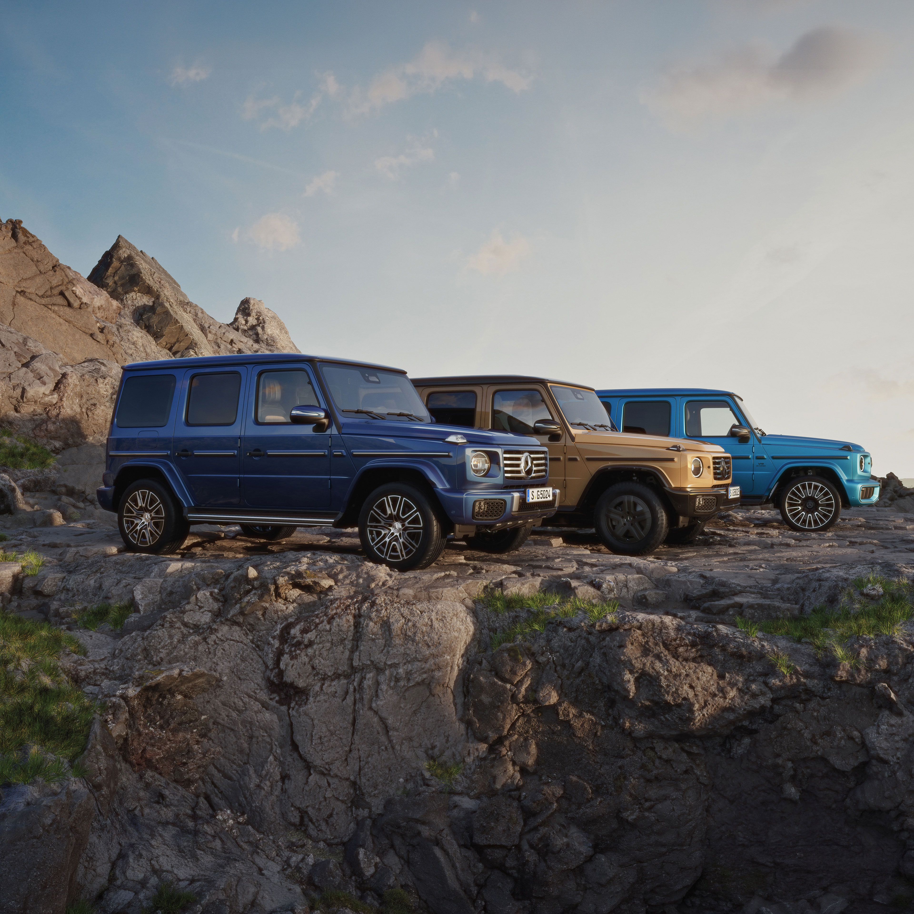 G-Klasse Markenbereich | Mercedes-Benz Drei verschiedene Mercedes-Benz G-Klassen auf einem Berg.