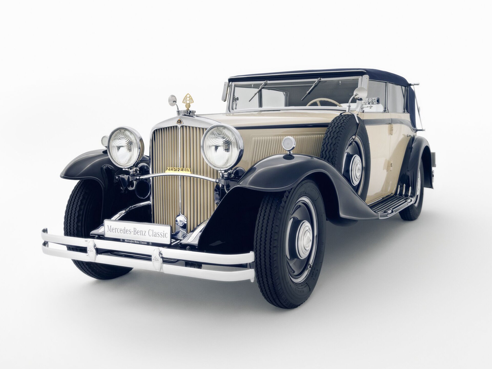 Ein historisches Fahrzeug in Zweifarbenlackierung von Mercedes-Maybach vor weißem Grund.