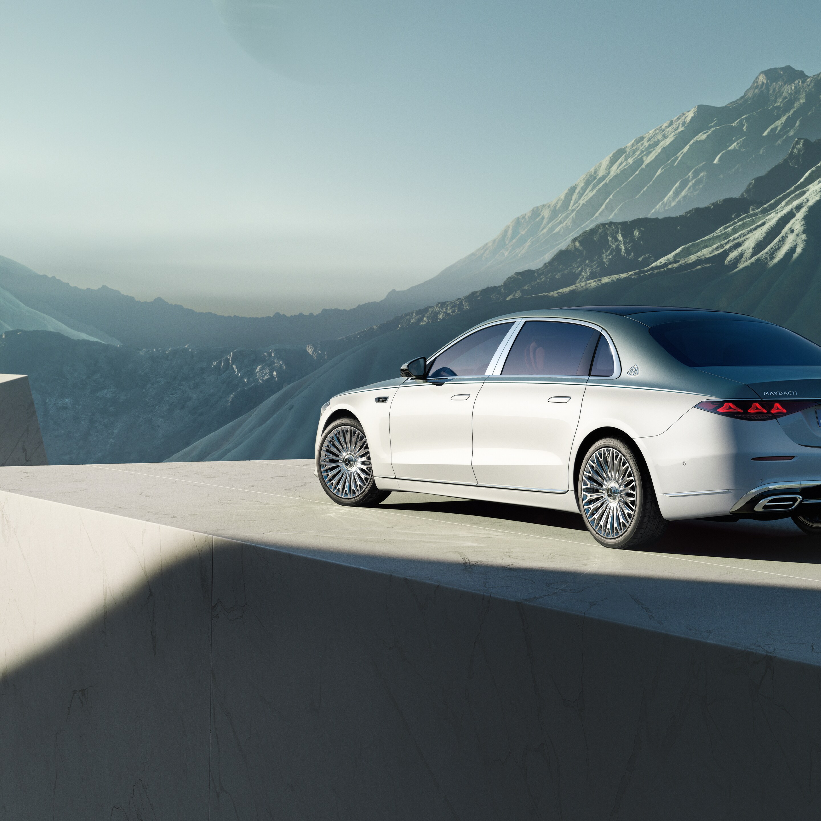 Die Mercedes-Maybach S-Klasse in einer seitlichen Ansicht parkend vor einer Berglandschaft.