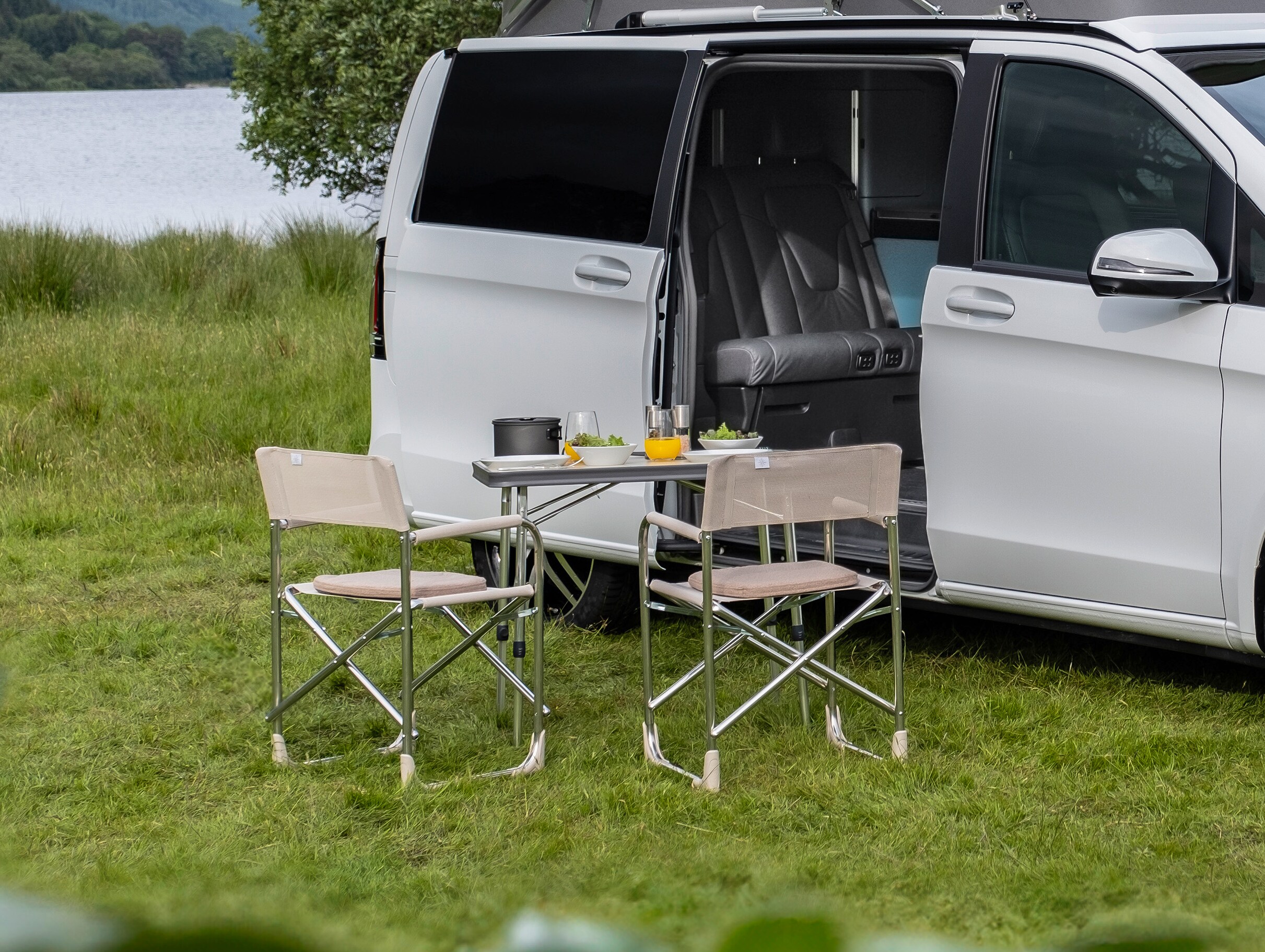 Der V-Klasse Marco Polo mit Campingtisch und 2 Stühlen.
