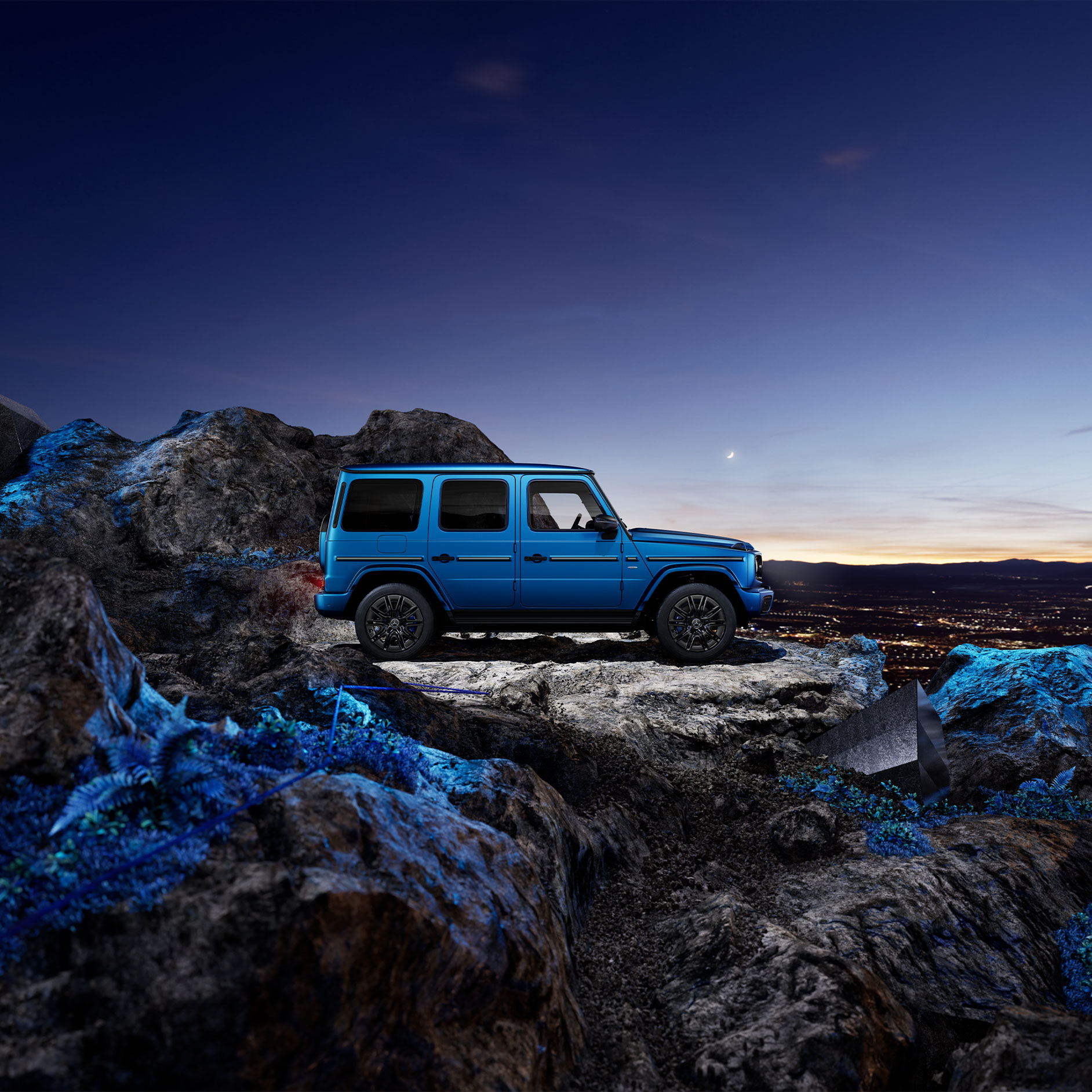 Werksabholung am G-Class Experience Center | Mercedes-Benz Eine blaue elektrische G-Klasse in einer Seitenansicht auf steinigem Grund bei Dunkelheit.