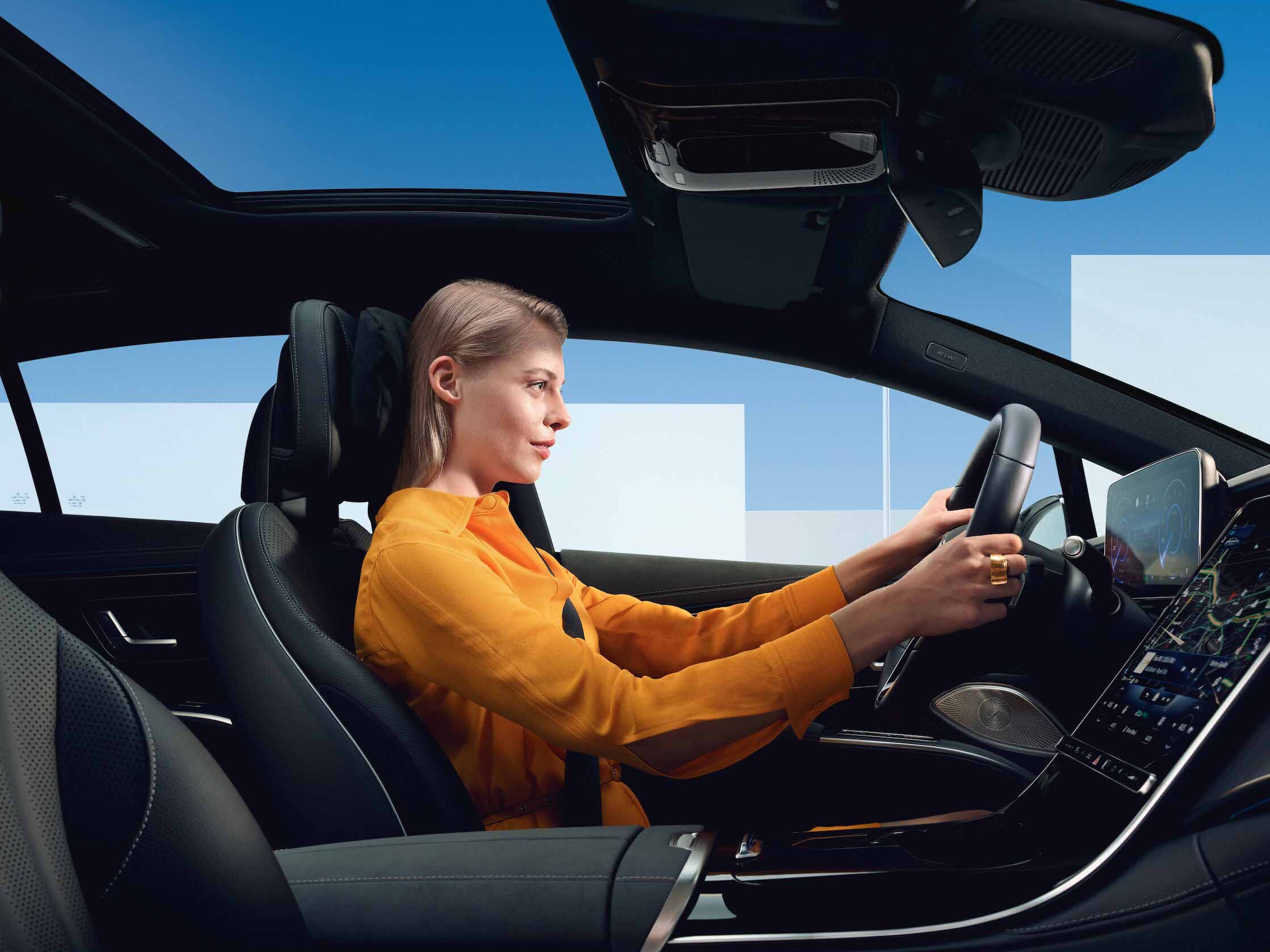 Eine Frau sitzt am Steuer ihres Mercedes-Benz.