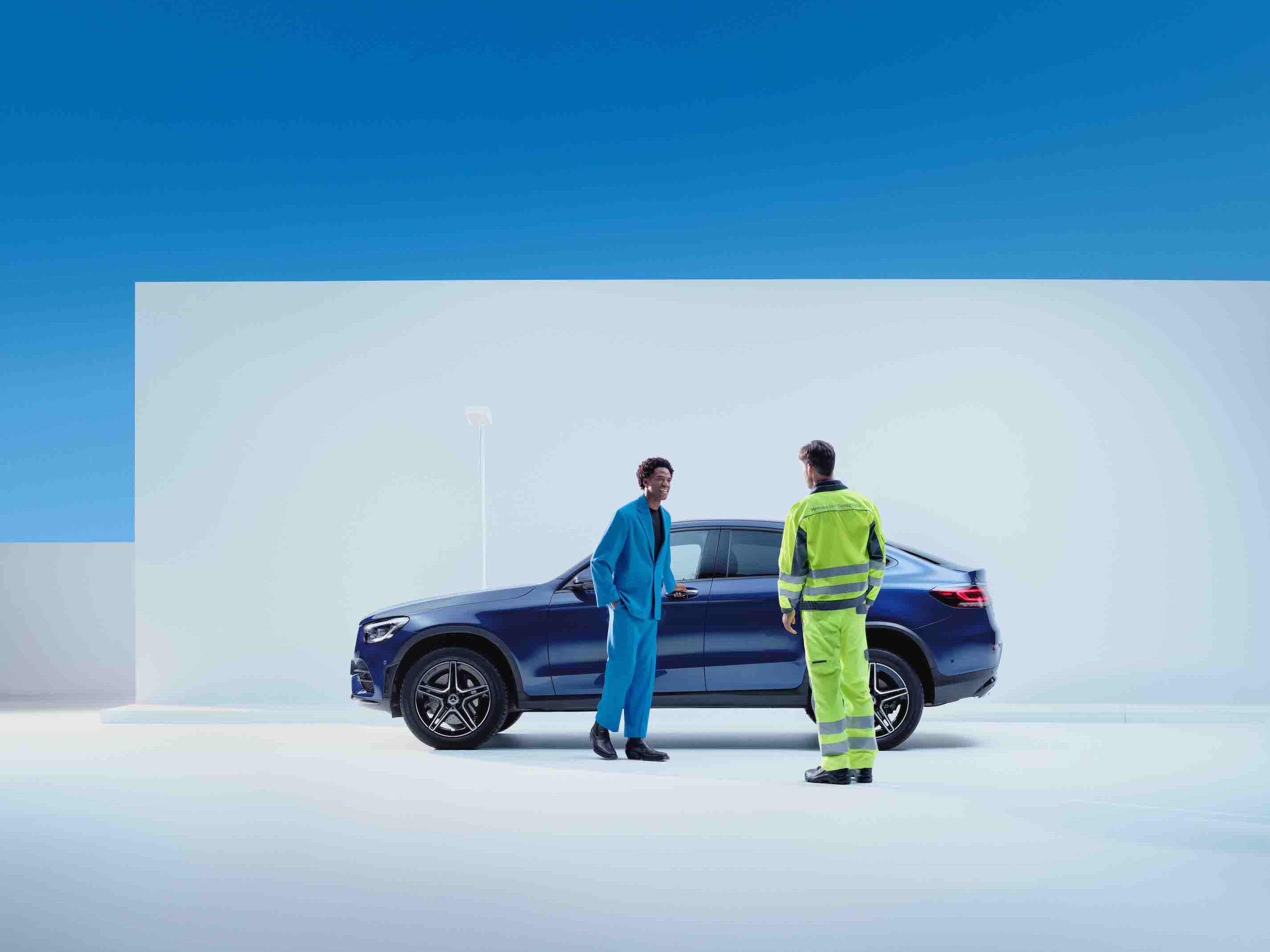 Ein Mann steht mit einem Service Mitarbeiter vor einem Mercedes-Benz.