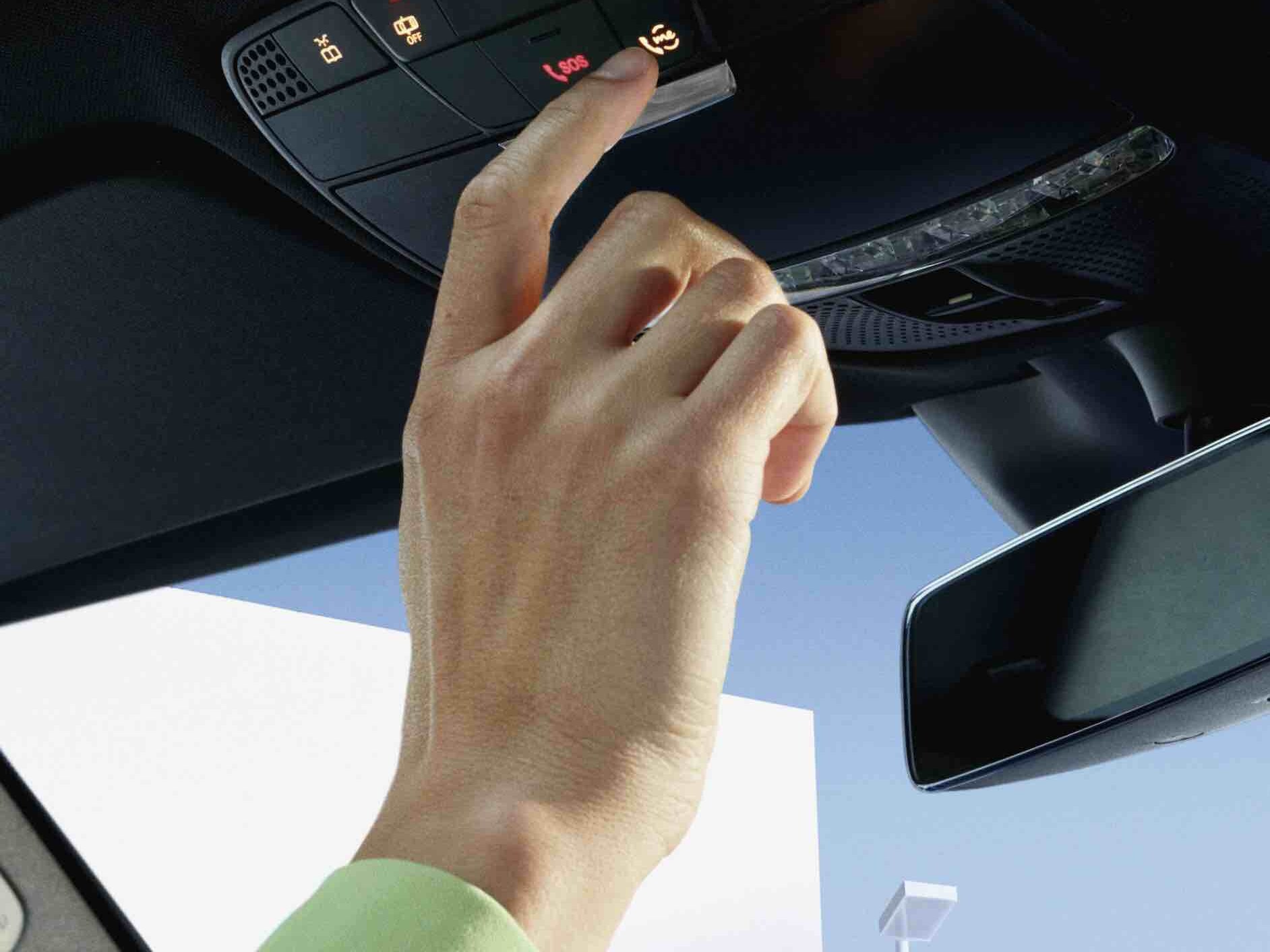 Eine Person drückt die Mercedes-Benz-Taste auf der Bedieneinheit