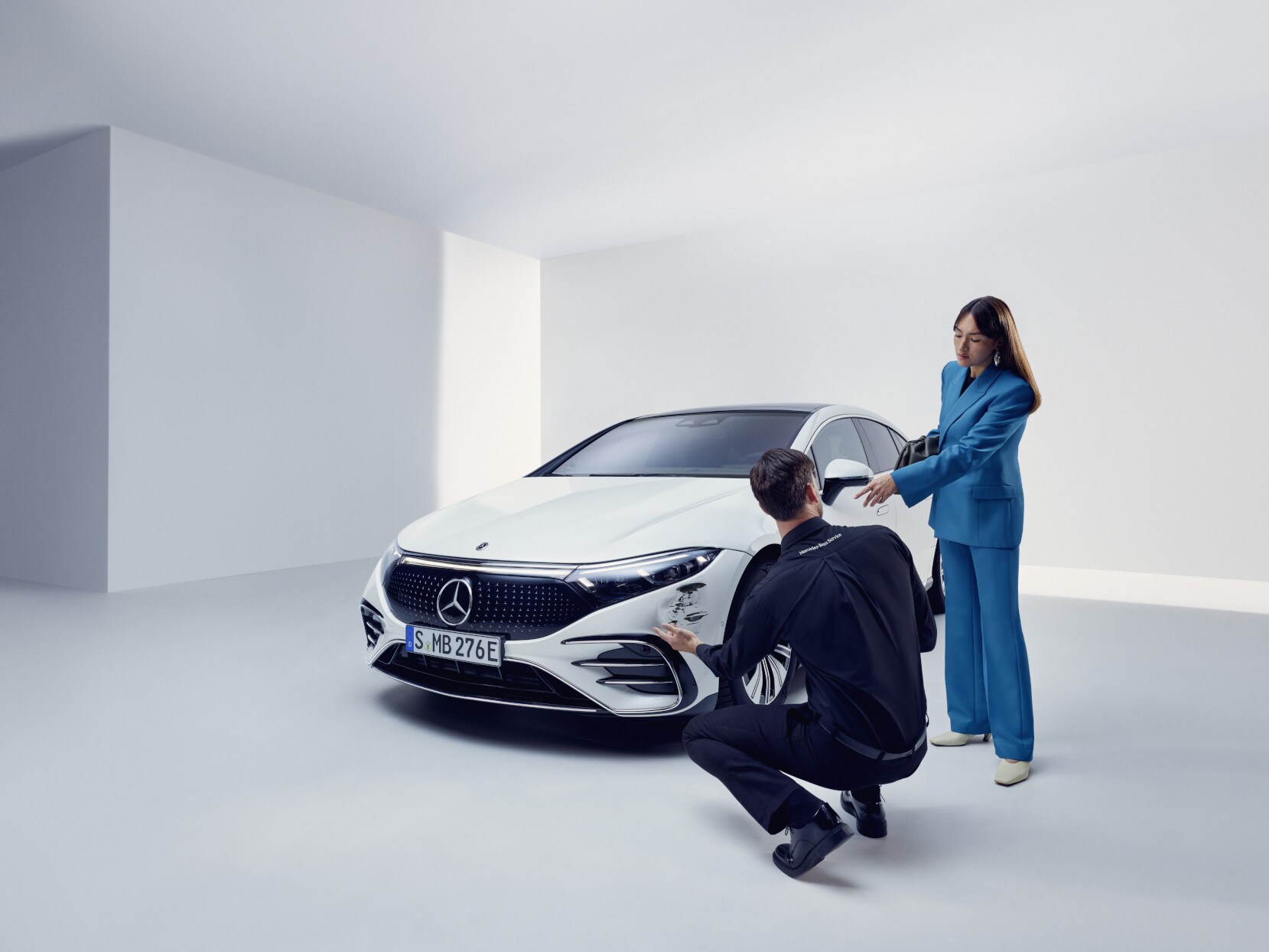 Ein Mitarbeiter des Mercedes-Benz Supportteams kniet neben einem beschädigten Mercedes-Benz.