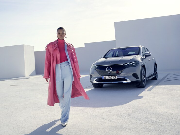 Eine Frau geht von ihrem Mercedes-Benz weg.