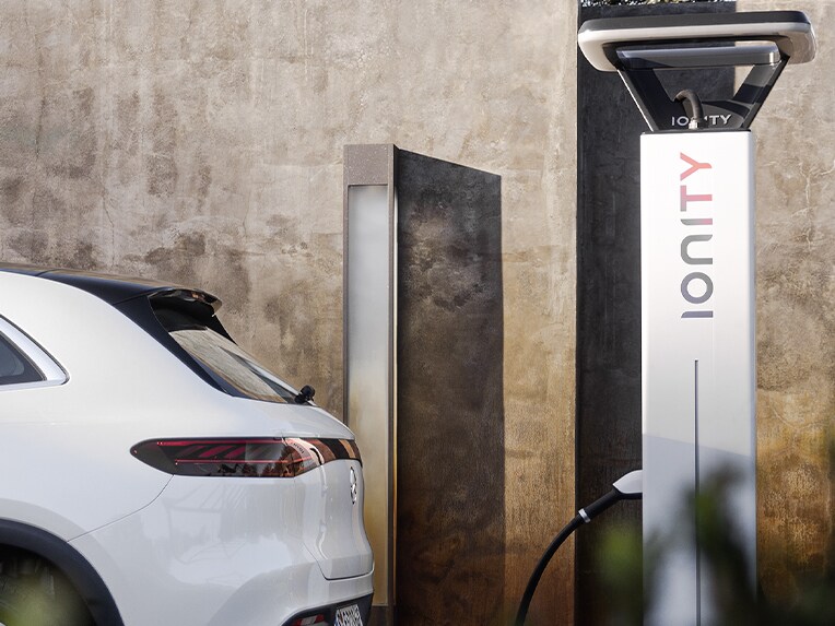 Ein Mann lädt seinen elektrischen Mercedes-Benz an einer IONITY-Ladestation auf.
