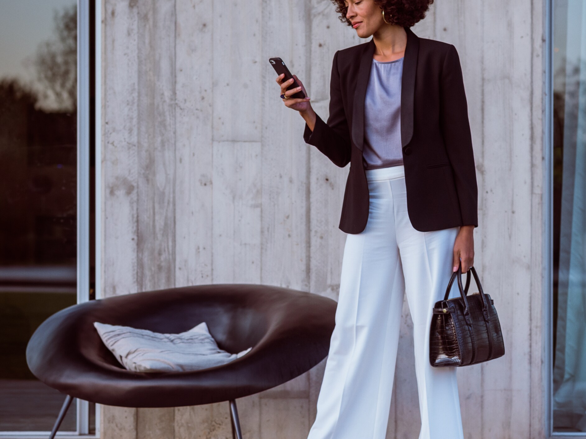 Eine Frau verbindet sich über ihr Smartphone, die Mercedes App und ihre Mercedes me ID mit ihrem Mercedes-Benz.