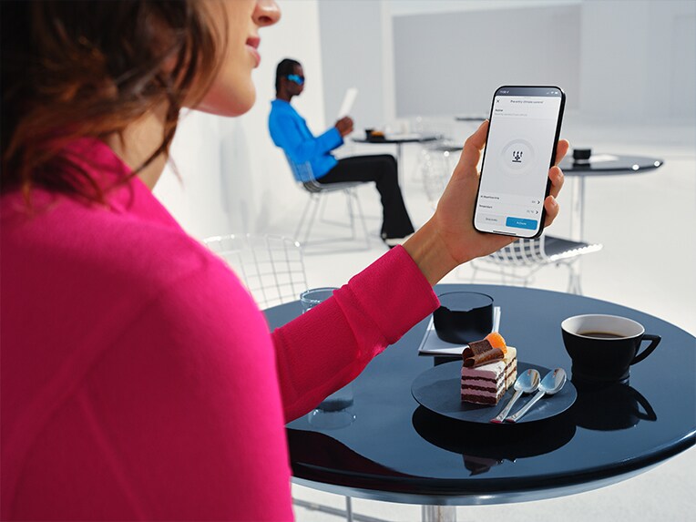 Eine Frau startet die Navigation auf einem Smartphone mit dem MBUX Multimediasystem von Mercedes-Benz.