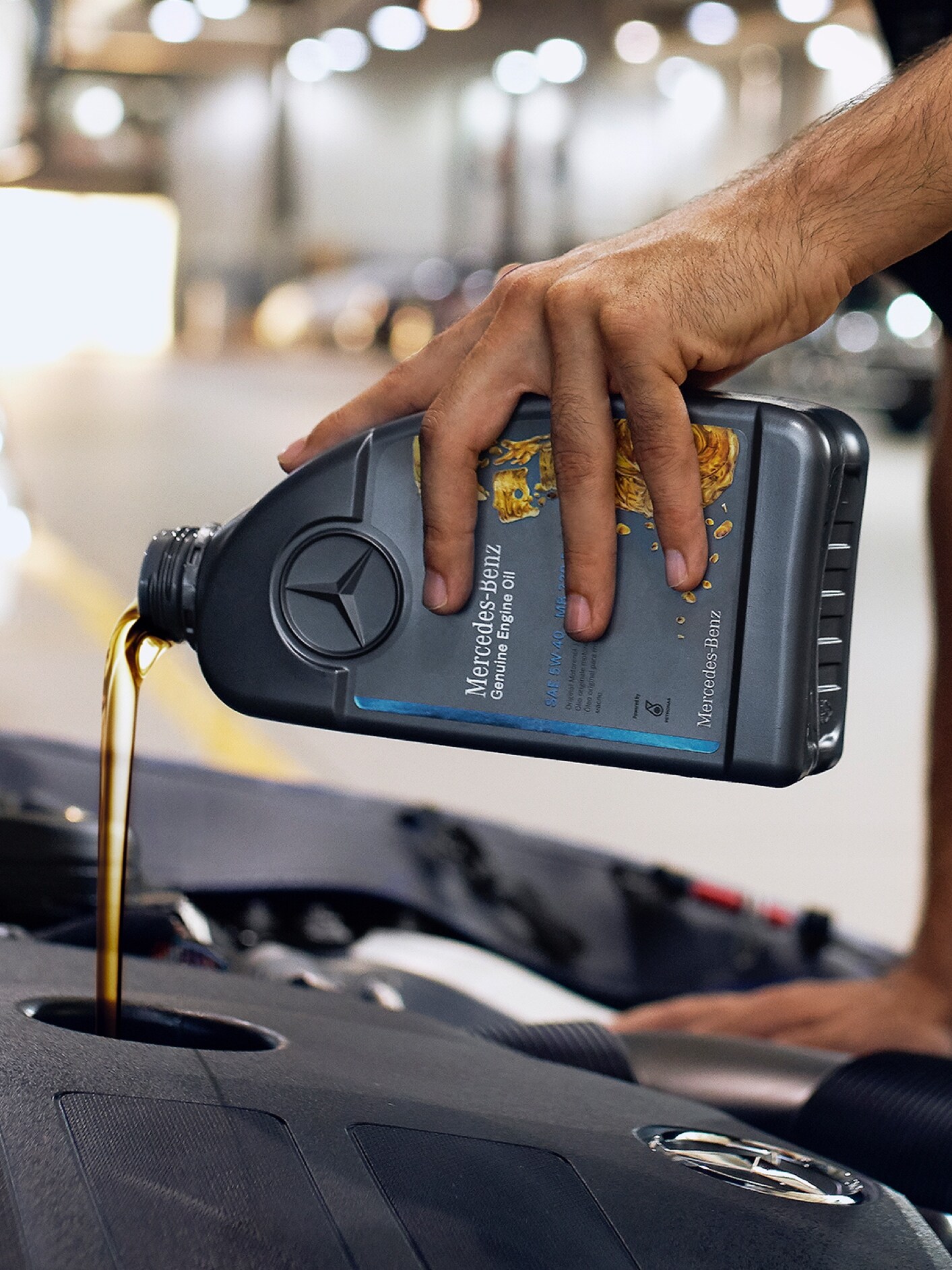 Eine Person, die Motoröl in das Mercedes-Benz Fahrzeug einfüllen.