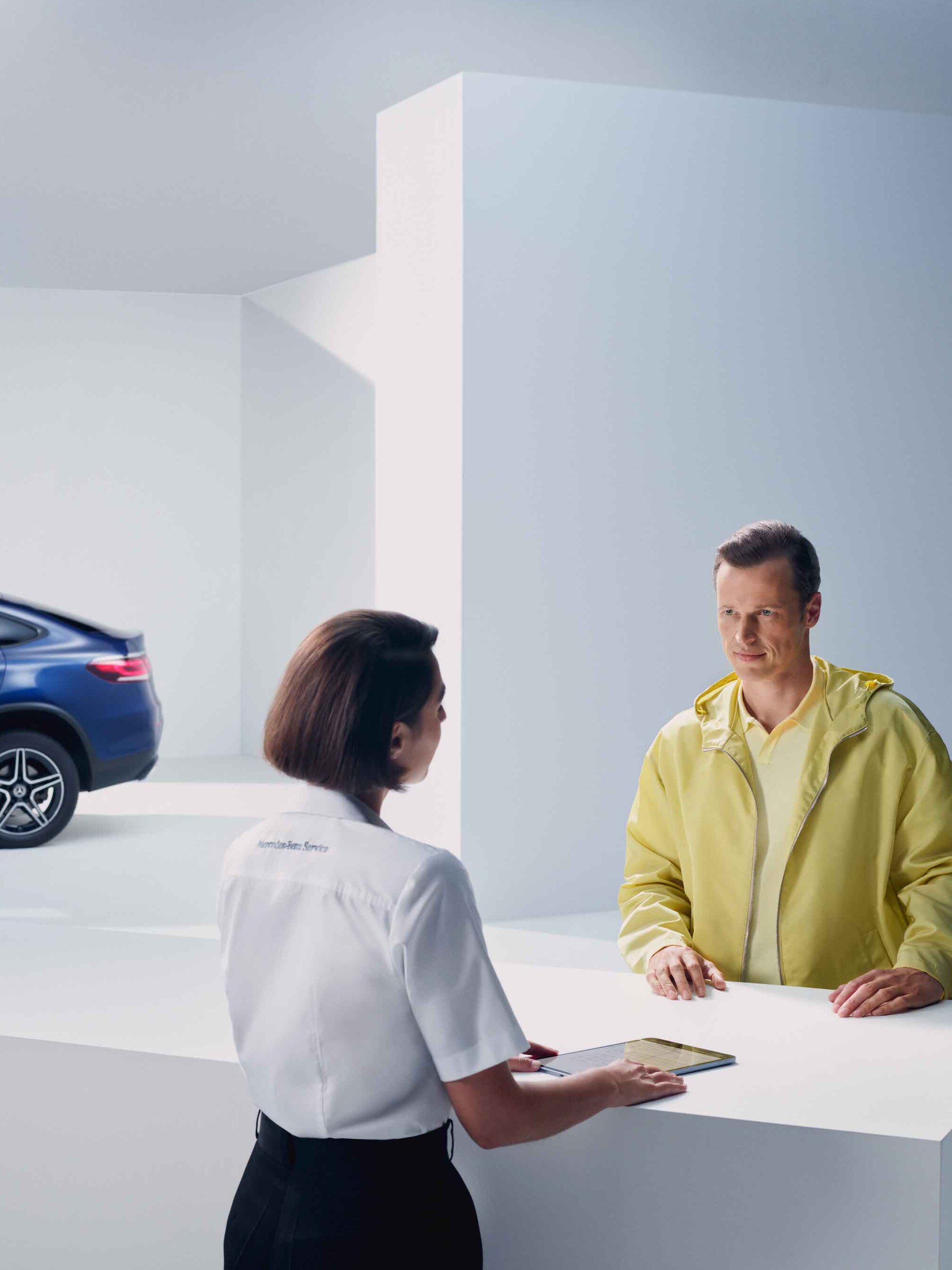 Ein Mann lässt sich von einer Mercedes-Benz Mitarbeiterin beraten.