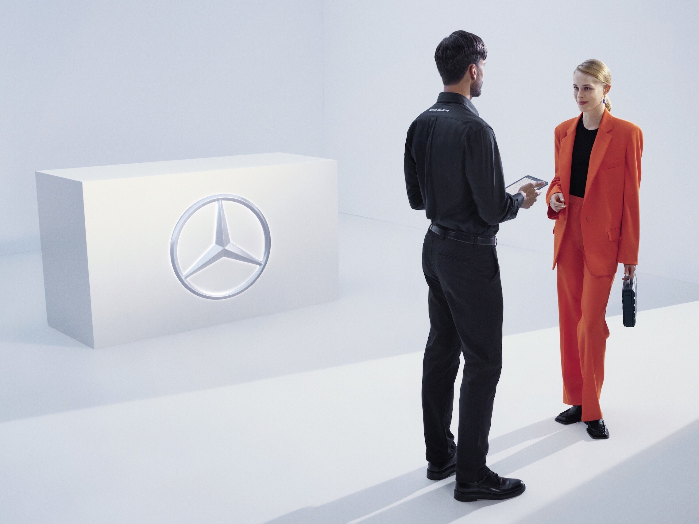 Eine Frau entspannt auf einer Bank vor ihrem Mercedes-Benz.