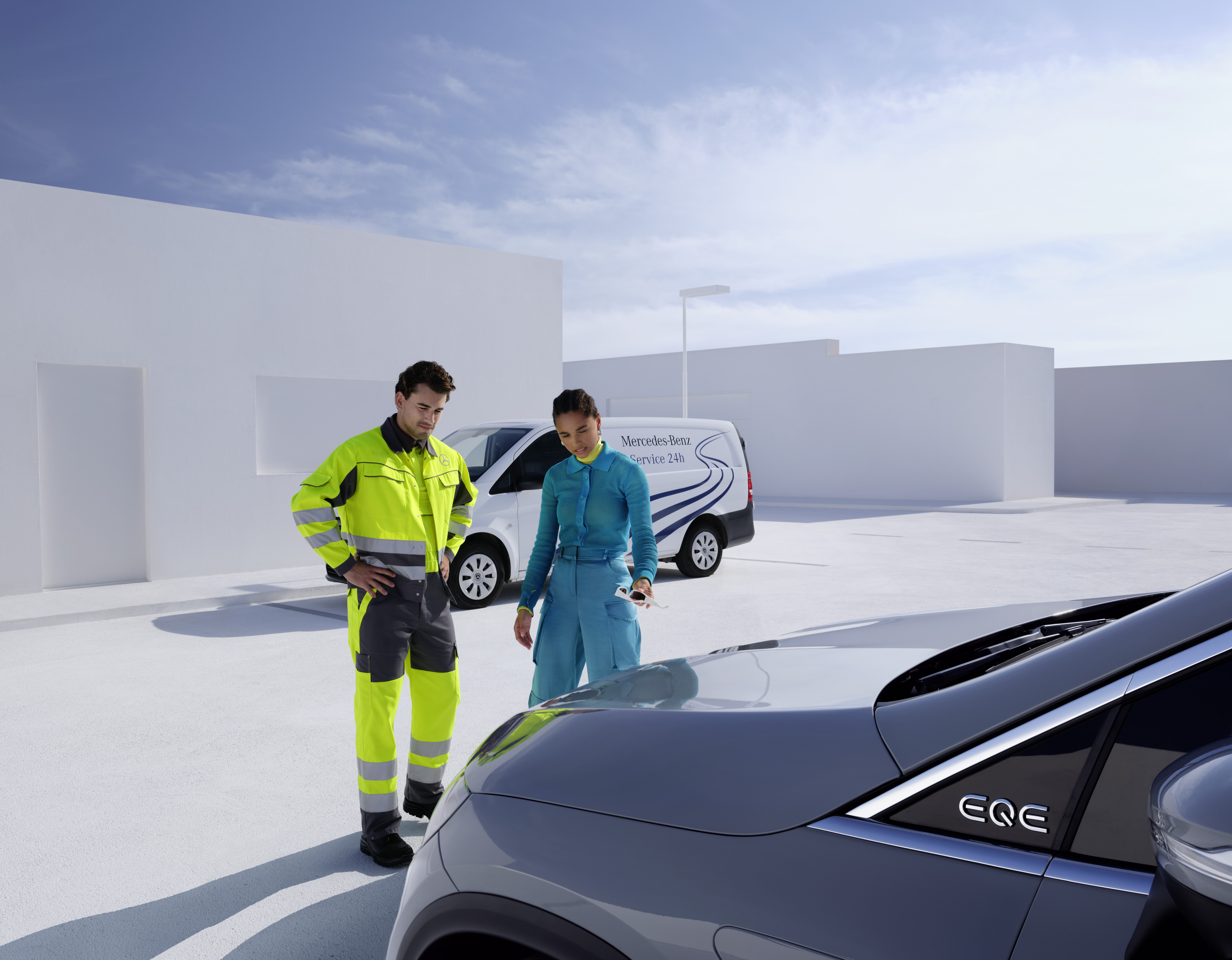 Pannenhilfe | Mercedes-Benz Ein Mann vom Mercedes-Benz Service-Team und eine Frau betrachten einen Mercedes-Benz