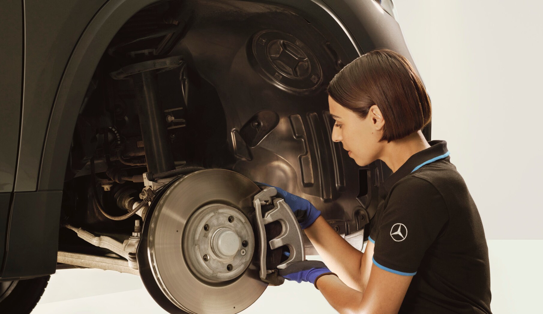 Ein Techniker repariert die Bremsen eines Mercedes-Benz Fahrzeugs.
