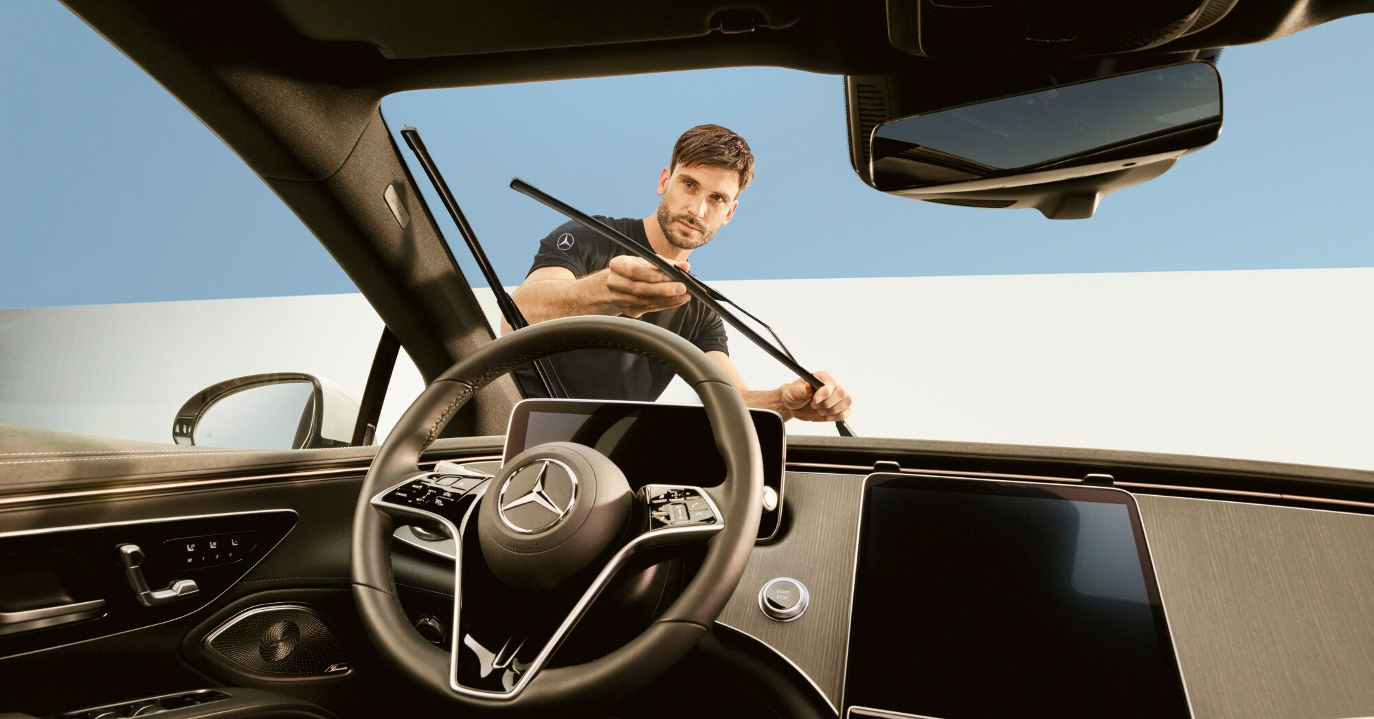 Ein Techniker repariert die Wischerblätter eines Mercedes-Benz Fahrzeugs.