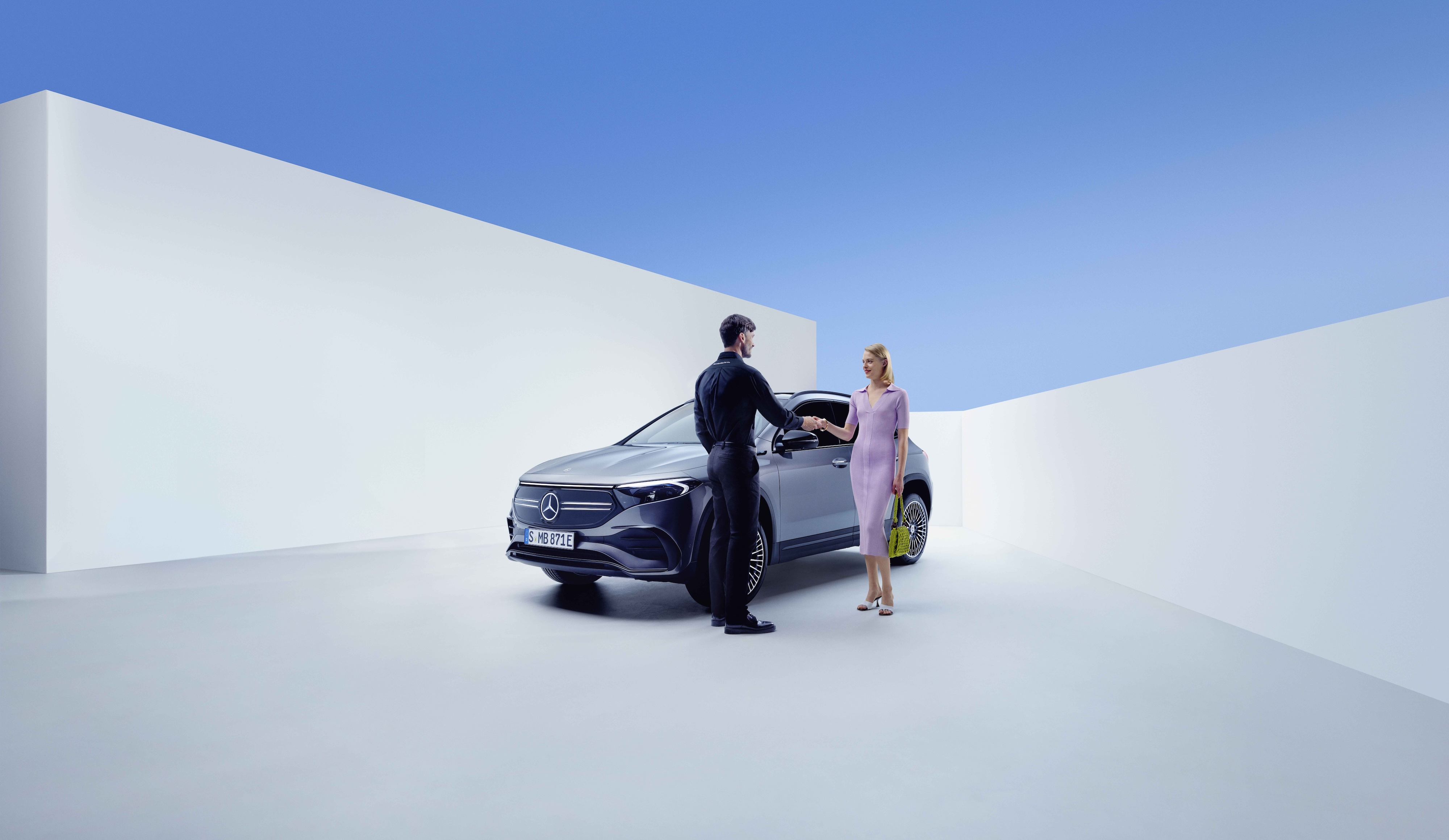 Service und Reparatur | Mercedes-Benz Ein Mercedes-Benz Mitarbeiter und eine Frau schütteln sich vor einem Mercedes-Benz die Hände