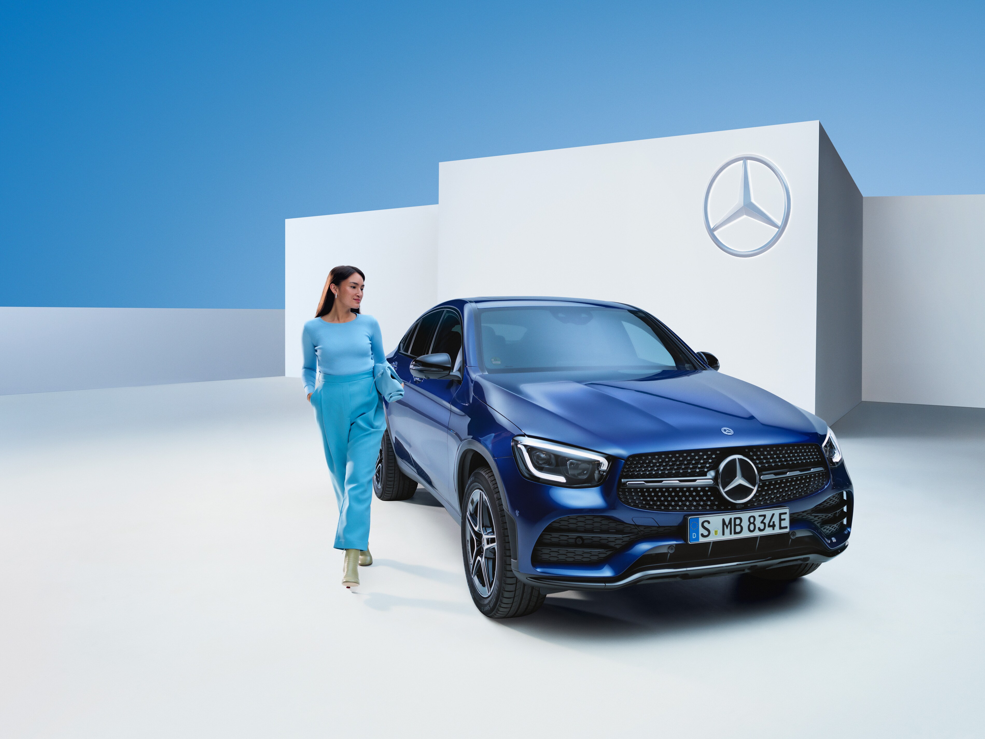 Eine Frau geht neben ihrem Mercedes-Benz.