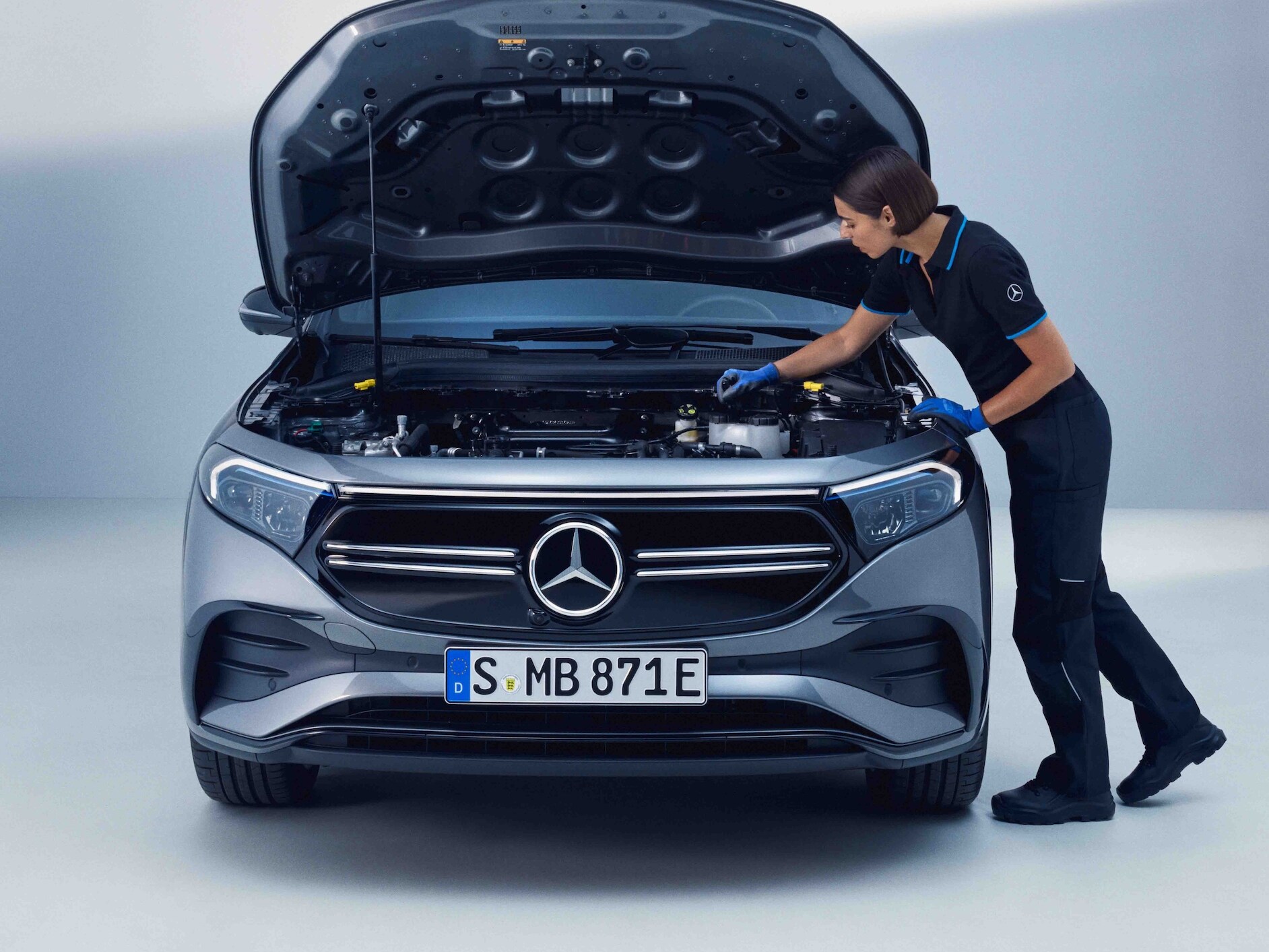 Eine Mercedes-Benz Technikerin überprüft einen Mercedes-EQ.