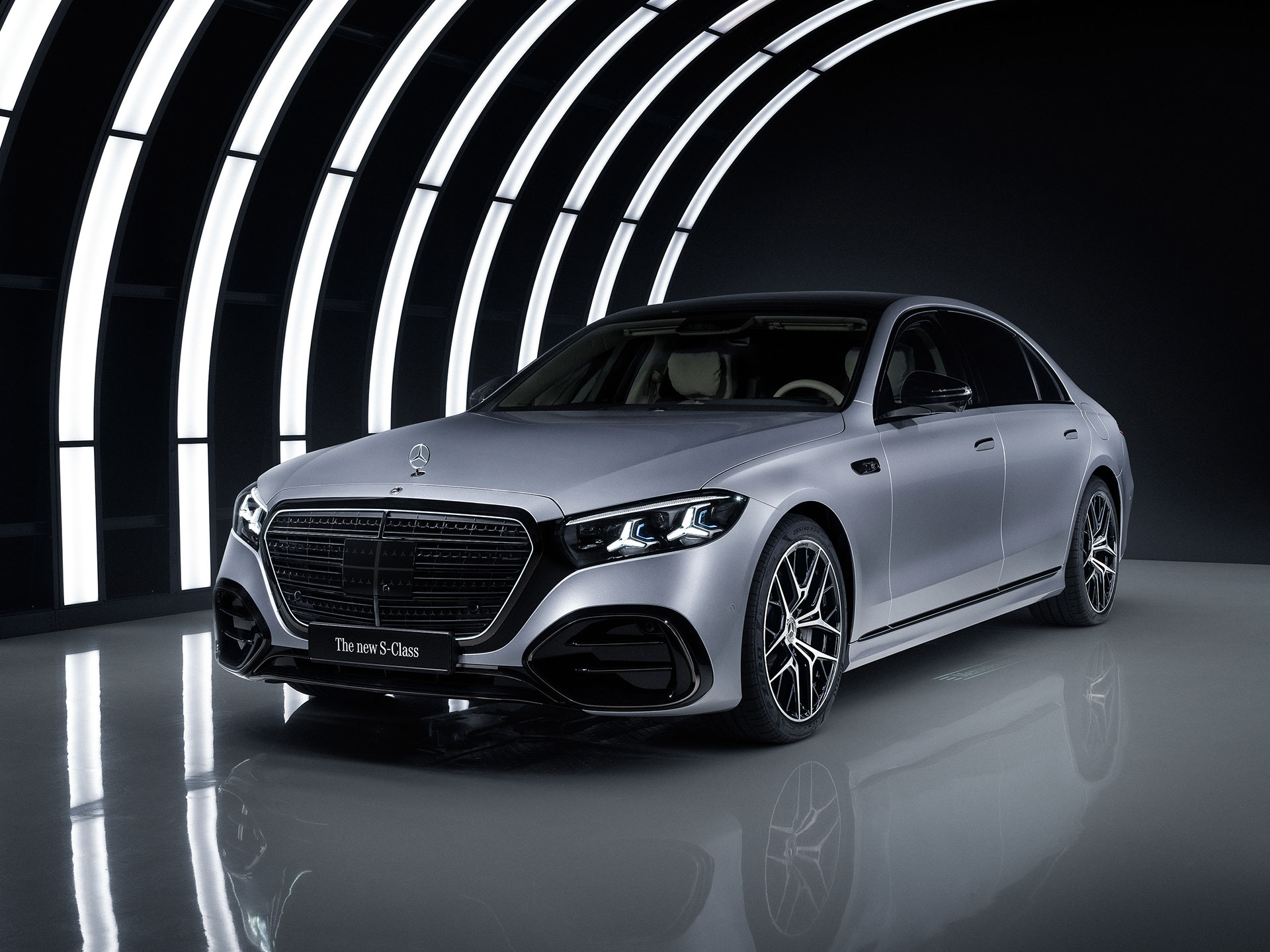 Automatisiertes Fahren & Assistenzsysteme | Mercedes-Benz Ein silberner Mercedes-Benz steht in einem Tunnel aus weißen Lichtern.