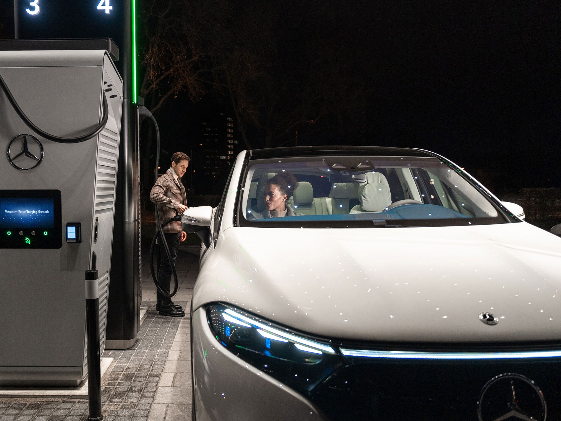 Eine Person lädt einen Mercedes-Benz EQS SUV an einer Ladestation