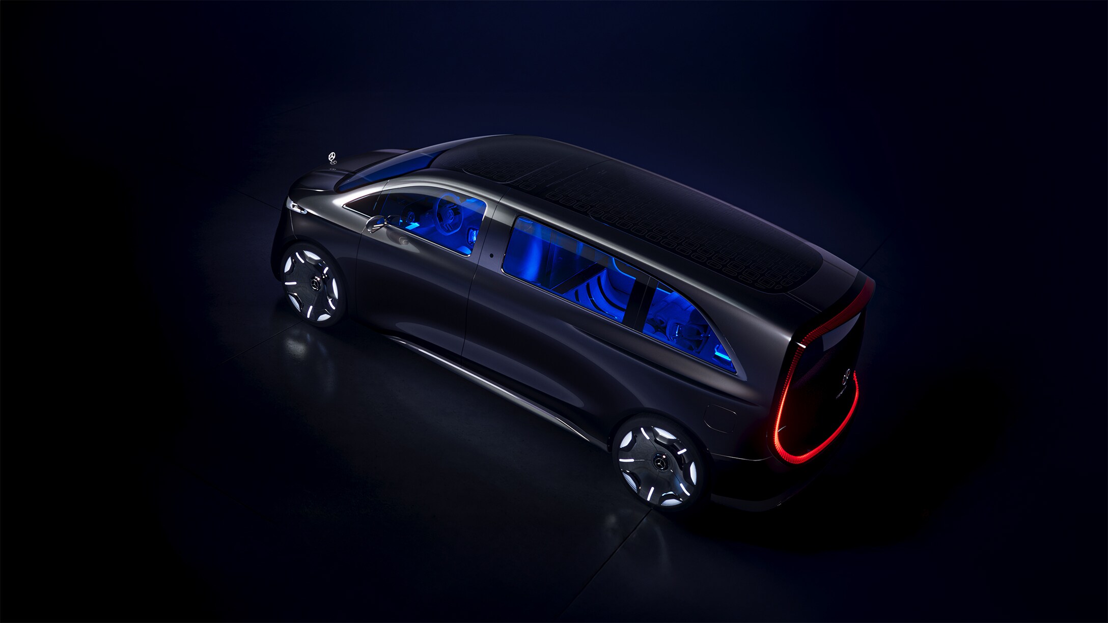 Das Showcar Vision V aus der Perspektive einer Überkopfkamera. In dem schwach beleuchteten Raum sind die markanten Rückleuchten und die Ambientebeleuchtung durch die Fenster besonders gut sichtbar.