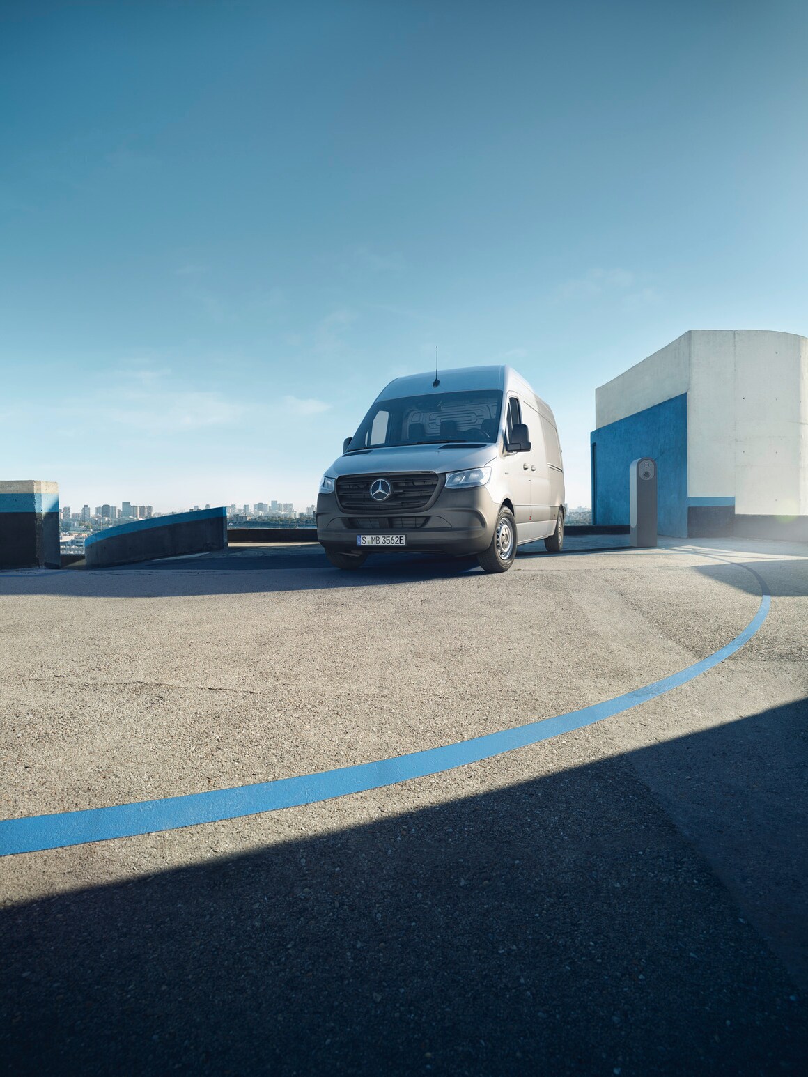 Der Mercedes-Benz eSprinter Kastenwagen steht auf dem sonnigen Dach eines Parkdecks.
