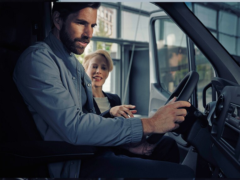 Mann sitzt im Mercedes-Benz eSprinter und spricht mit einem Händler