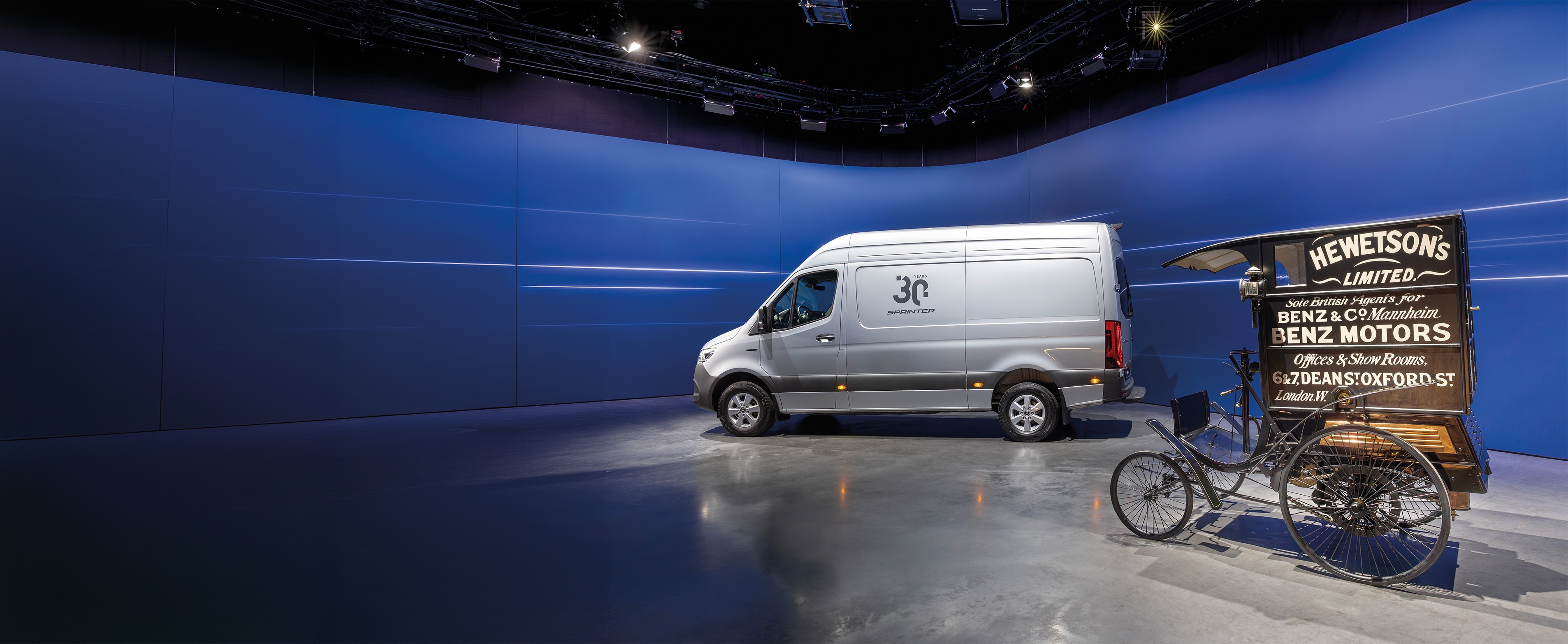 Geschichte | Mercedes-Benz Transporter. Mercedes-Benz Sprinter und historischer Benz Lieferungs-Wagen, ausgestellt in einem modernen Showroom