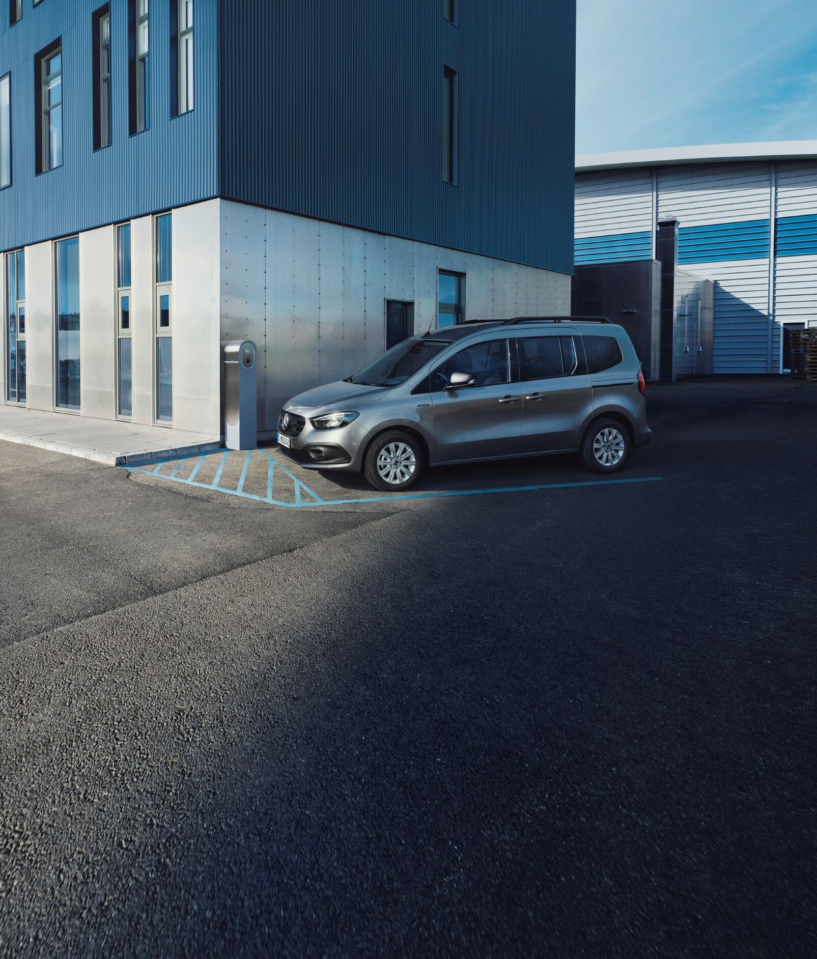 Eine Mercedes-Benz eCitan parkt vor ein Gebäude.