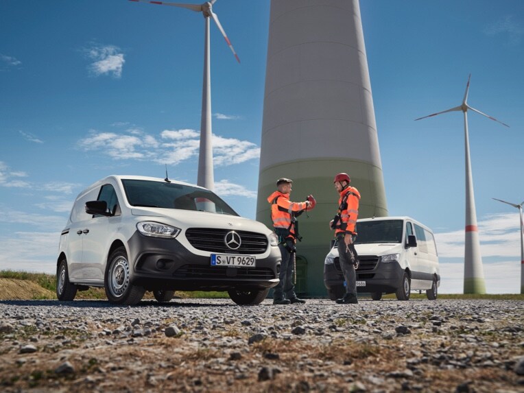 Zwei Transporter von Mercedes-Benz auf einer Baustelle.