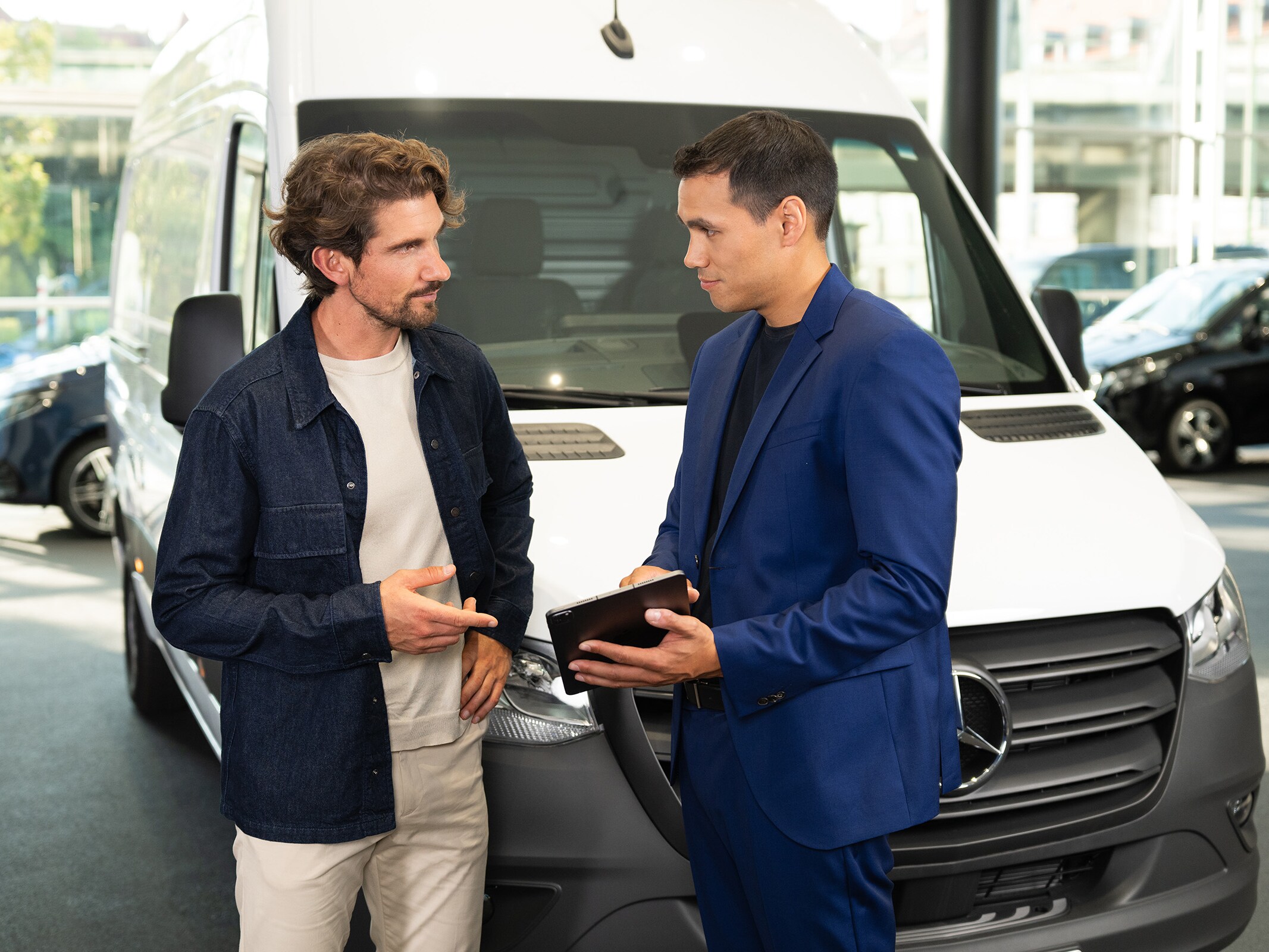 Beratung zu Mercedes-Benz Transportern in einem Showroom, bei der der kundenorientierte Service im Vordergrund steht.