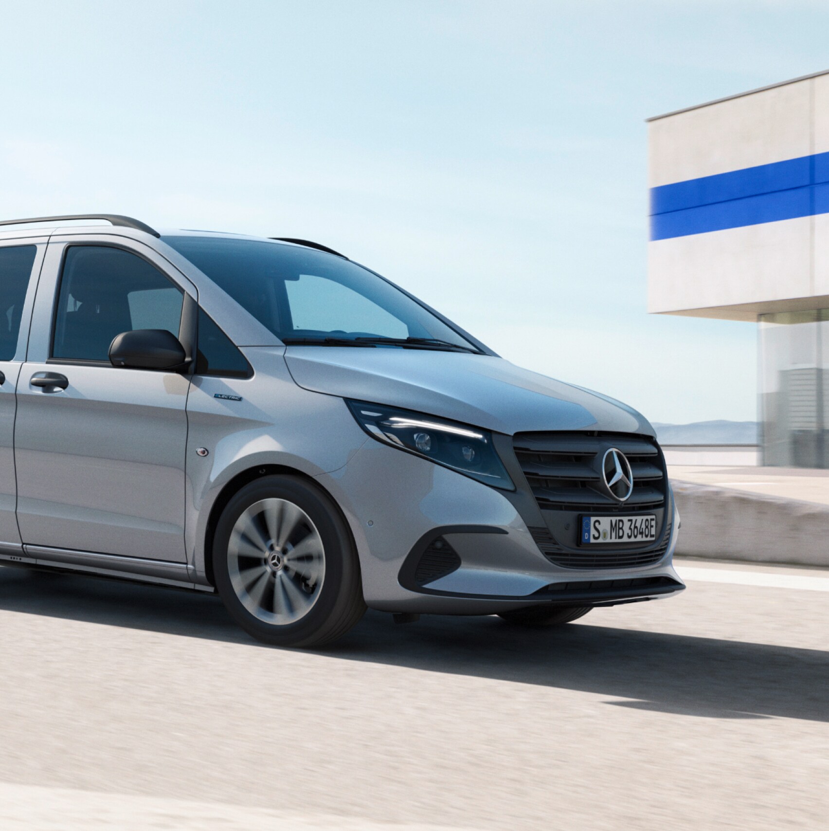 Ein hellgrauer Mercedes-Benz eVito Tourer auf dem Dach eines Parkhauses in der Sonne.