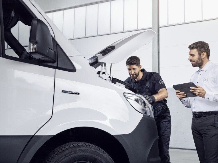 Zwei Mercedes-Benz Mitarbeiter schauen in den Motor eines weißen Vitos.