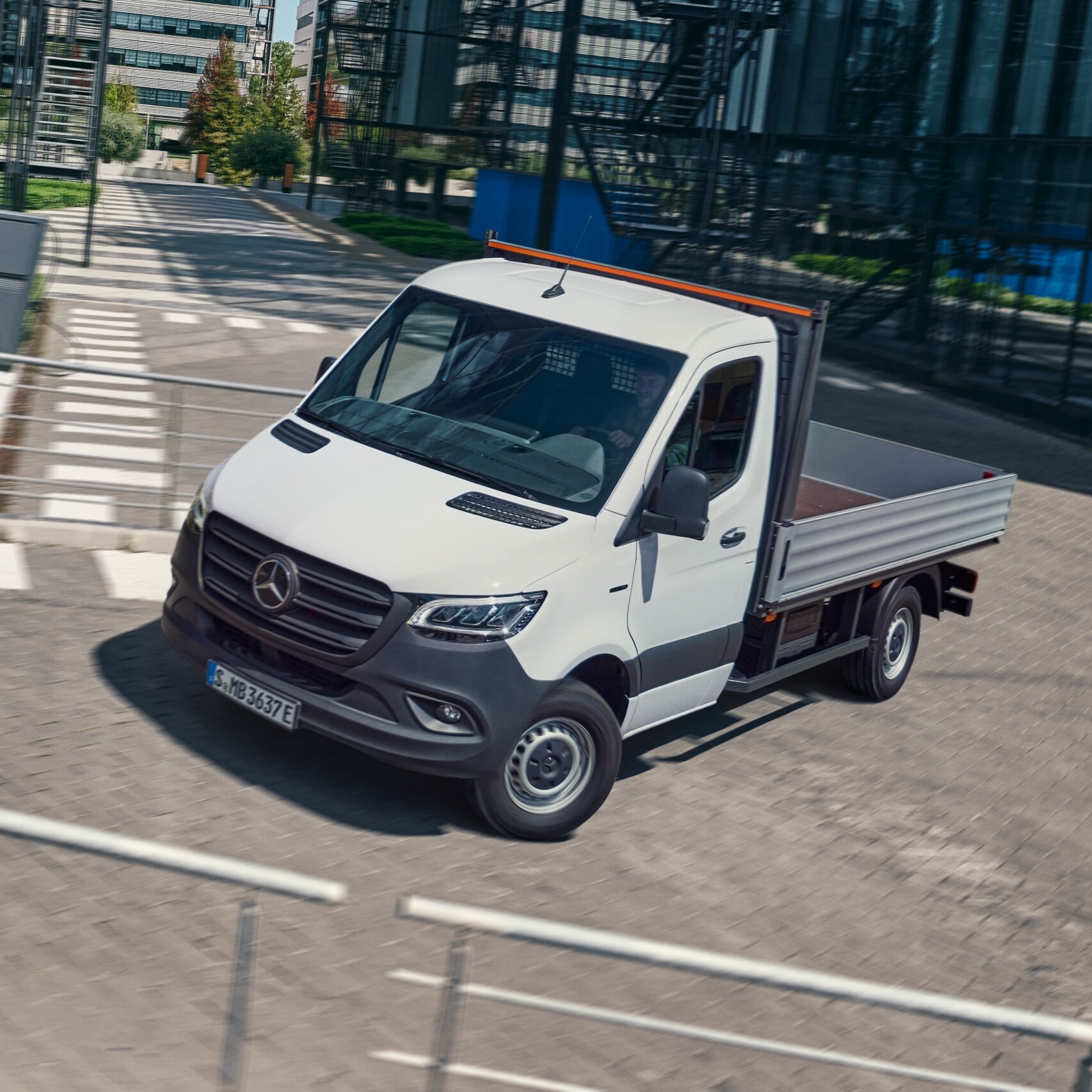 Ein Fahrgestell von Mercedes-Benz biegt um eine Ecke an einer Brücke.