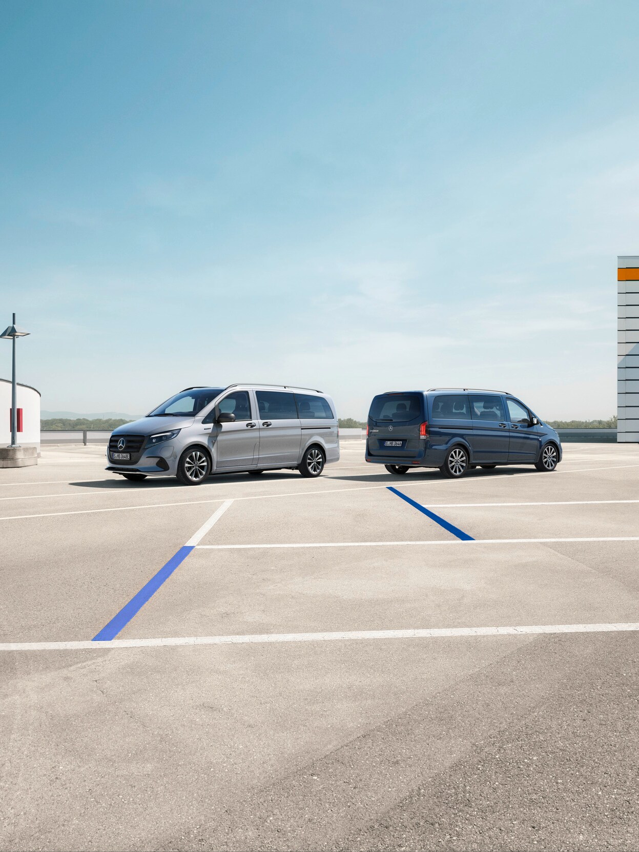 Der Vito Tourer und der eVito Tourer von Mercedes-Benz stehen auf einem Parkplatz.