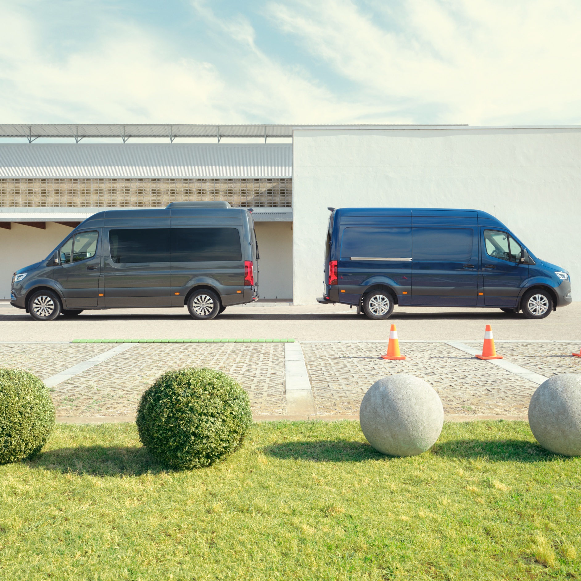Kontakt | Sprinter | Mercedes-Benz Der Mercedes-Benz Sprinter Tourer und Kastenwagen auf einem Parkplatz vor einem Gebäude.