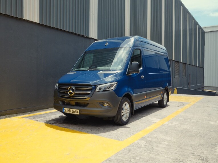 Der Mercedes-Benz Sprinter Kastenwagen parkt vor einer Lagerhalle.