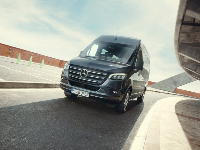 Der Mercedes-Benz Sprinter Tourer fährt auf einem Parkplatz.